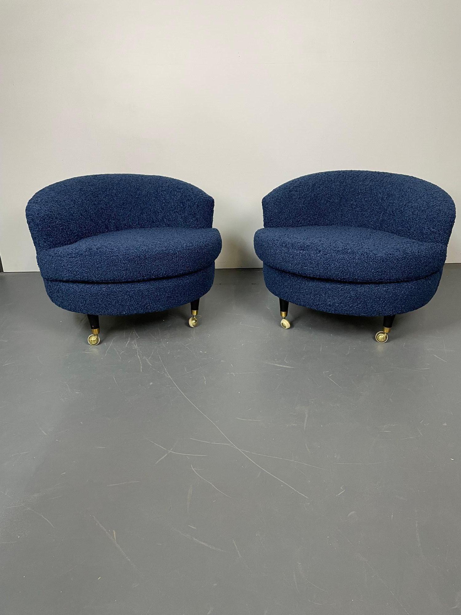 Pair of mid-century rolling swivel lounge / slipper chairs, Baughman Style
Low profile pair of rounded swivel chairs having ebony legs sitting on wheels. Newly re-upholstered in a fun and luxurious blue faux Sherpa/boucle material. Chair maintains