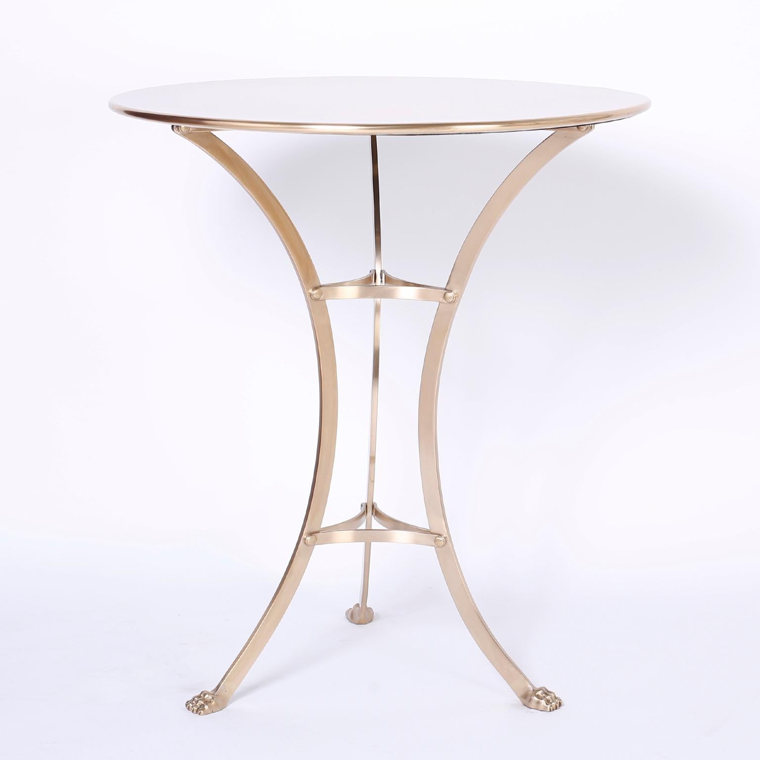 Chic pair of neoclassic tables or gueridons with simple round tops over three saber legs with cat claw feet. Hand polished and lacquered for easy care.
