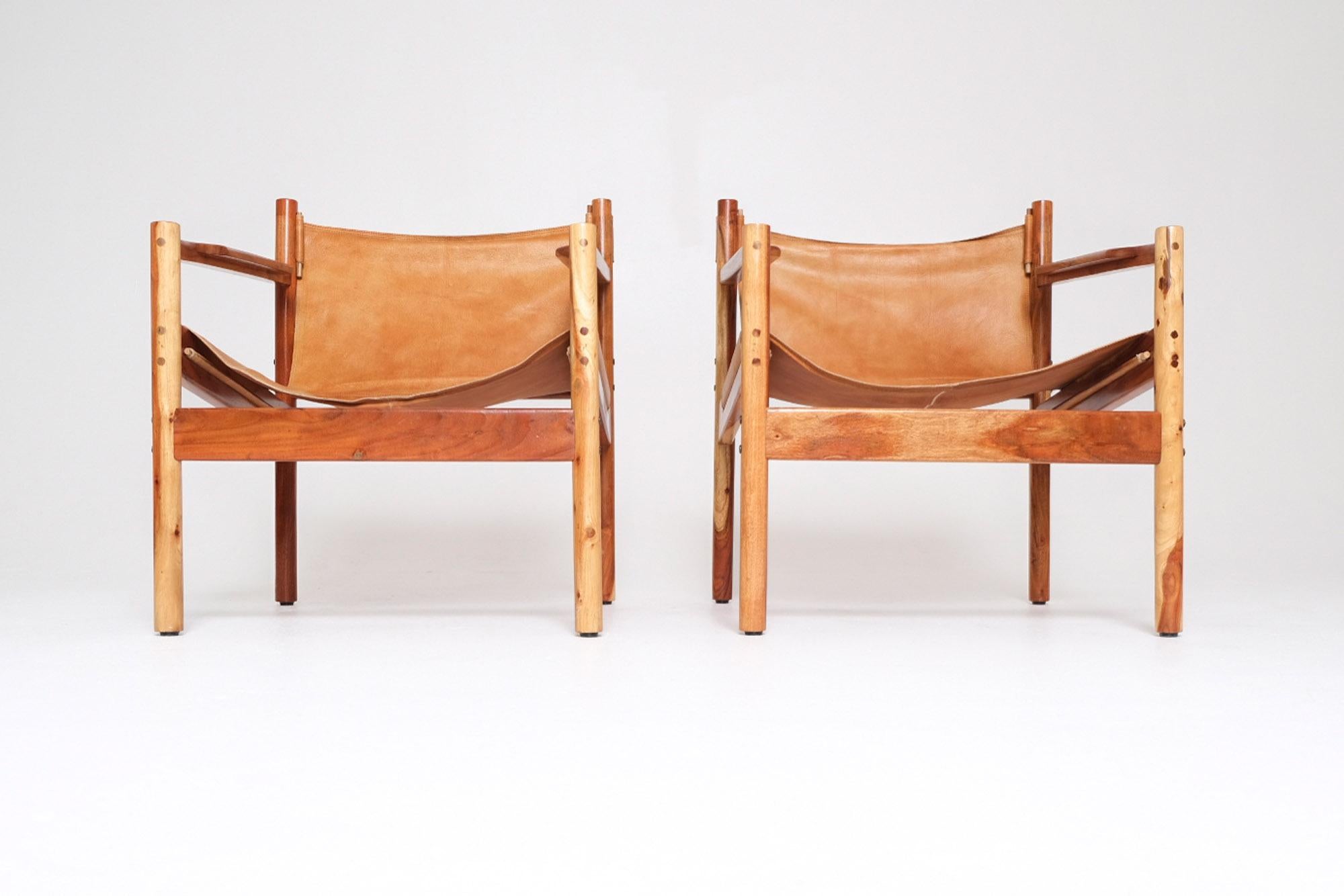 Paire de chaises longues safari du milieu du siècle, fabriquées dans les années 1960 avec des cadres en bois d'acacia massif et des harnais en cuir naturel. Les tons chauds et le grain expressif de l'acacia soulignent la qualité sculpturale du