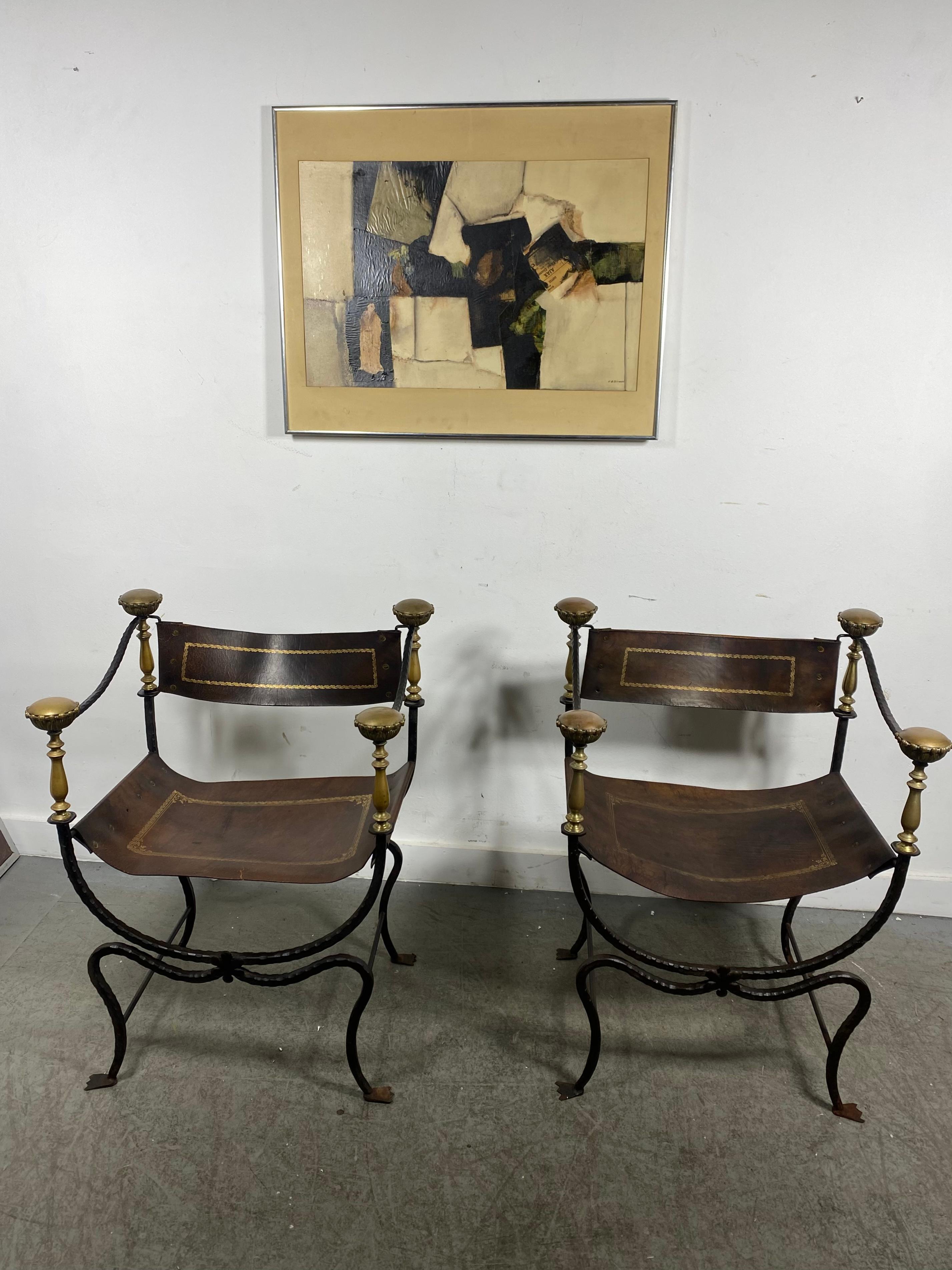 Pair of 20th century Italian iron ,bronze and leather Savonarola chairs,, Retain original tooled leather seats and backs,, minor tear to one chair (see photo). also a few missing grommets.Iron frames showing minor rust,, Hand delivery avail to New