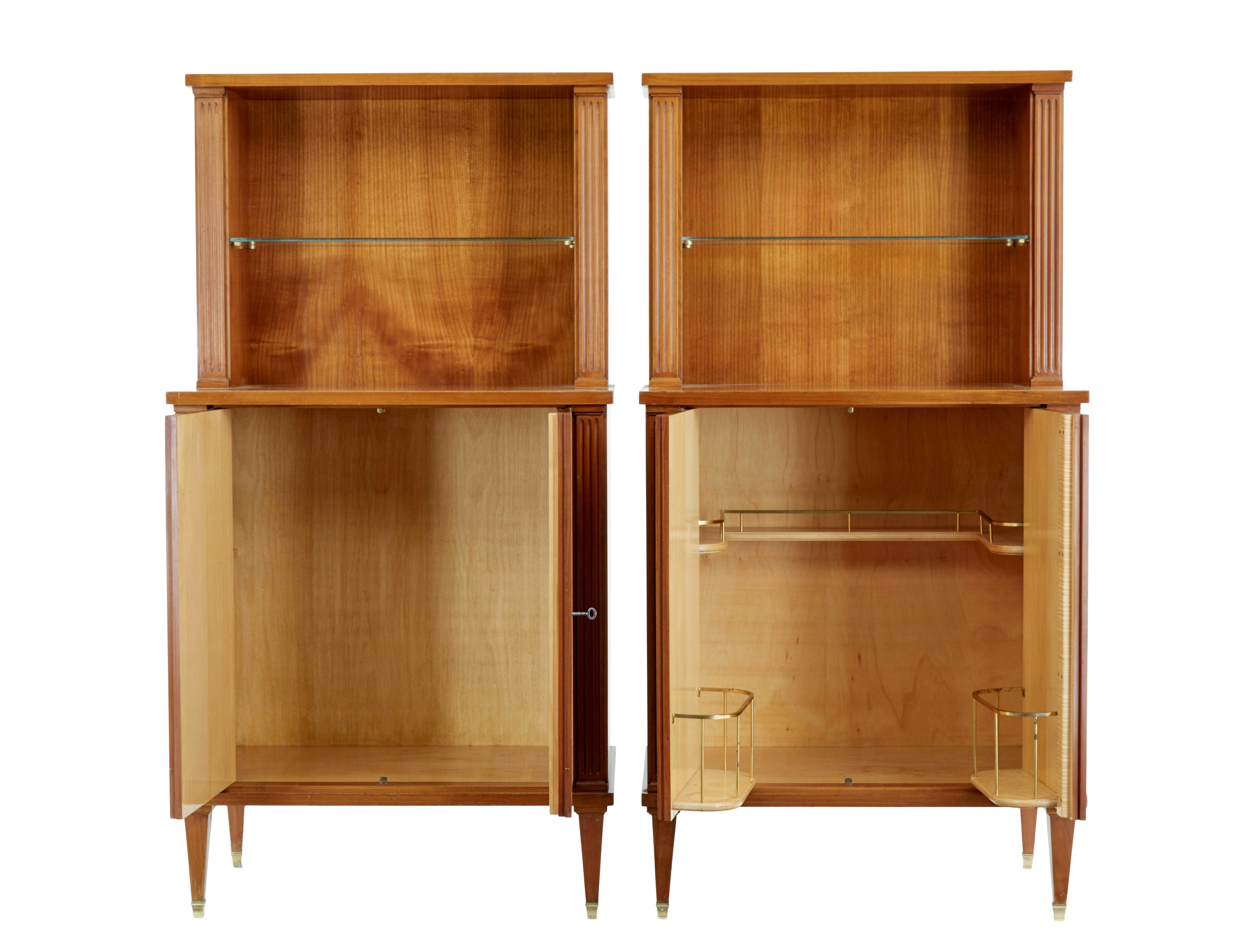 Pair of mid century Scandinavian elm cabinets circa 1950.

Very good quality pair of elm cabinets, with empire and art deco influences.

Each made in 1 piece, both feature and open aperture with a single glass shelf held in place by brass brackets. 