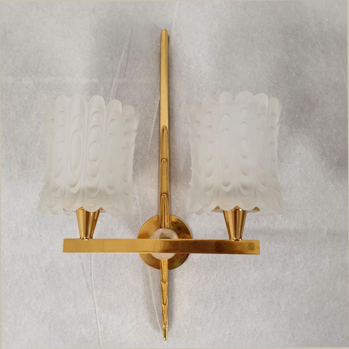 Pair of Mid Century wall sconces, France circa 1940s.
The elegant sconces are made of cast brass and frosted glass.
The style is Mid Century Modern with an Art Deco touch.
Each wall light has 2 lights and the pair is professionally rewired for the