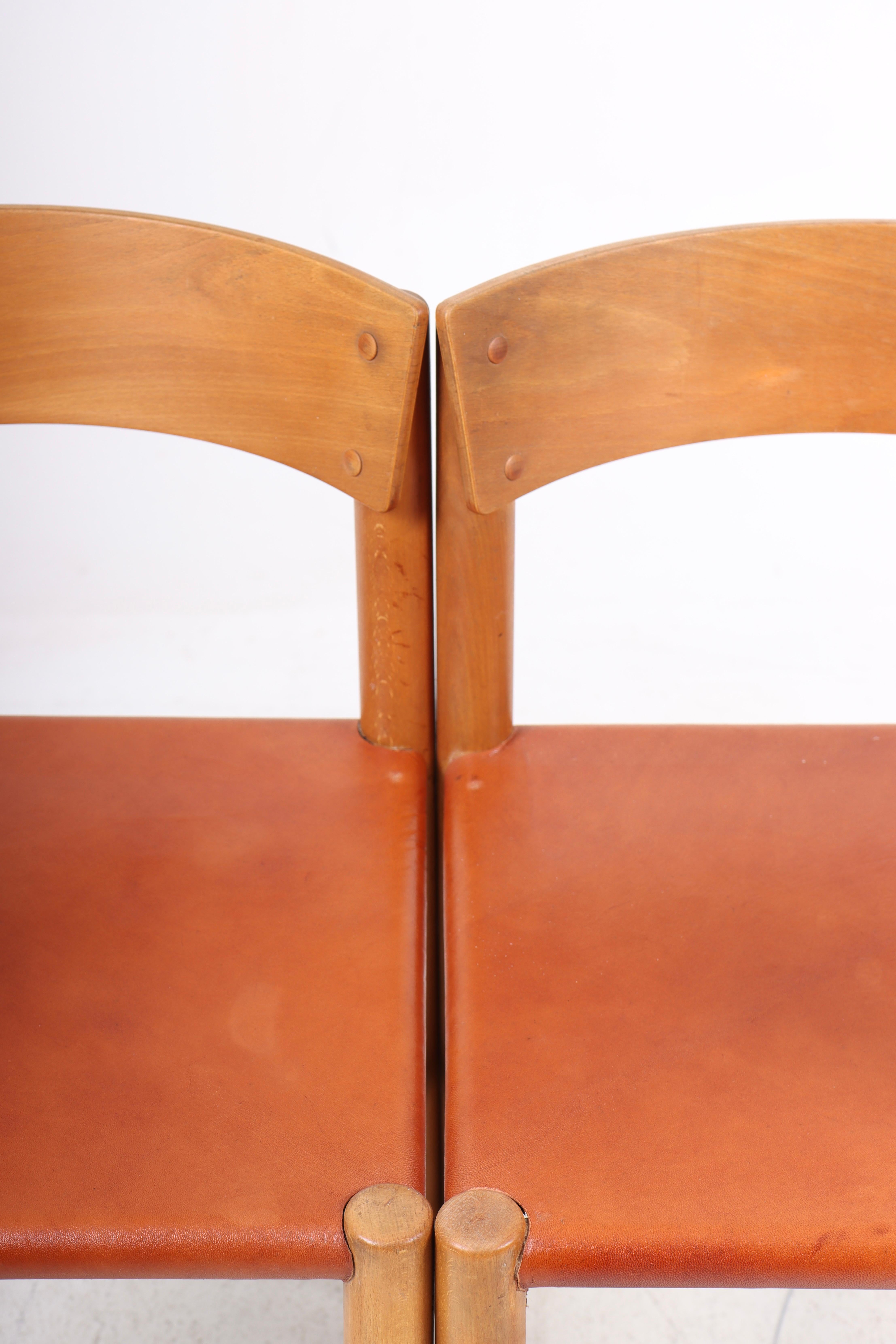 Pair of side chairs in patinated leather and beech. Designed by Mogens Lassen and made by Fritz Hansen in Denmark, great condition.