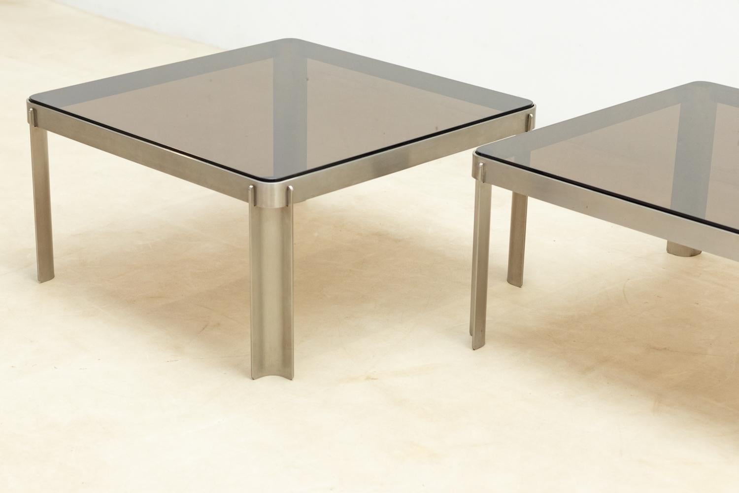Pair of side tables attributed to Osvaldo Borsani for Tecno. 
The base features curved steel with a smoked glass top.

The glass top might show slight traces of use. 
The base is in great condition.

Do not hesitate to contact us for any additional