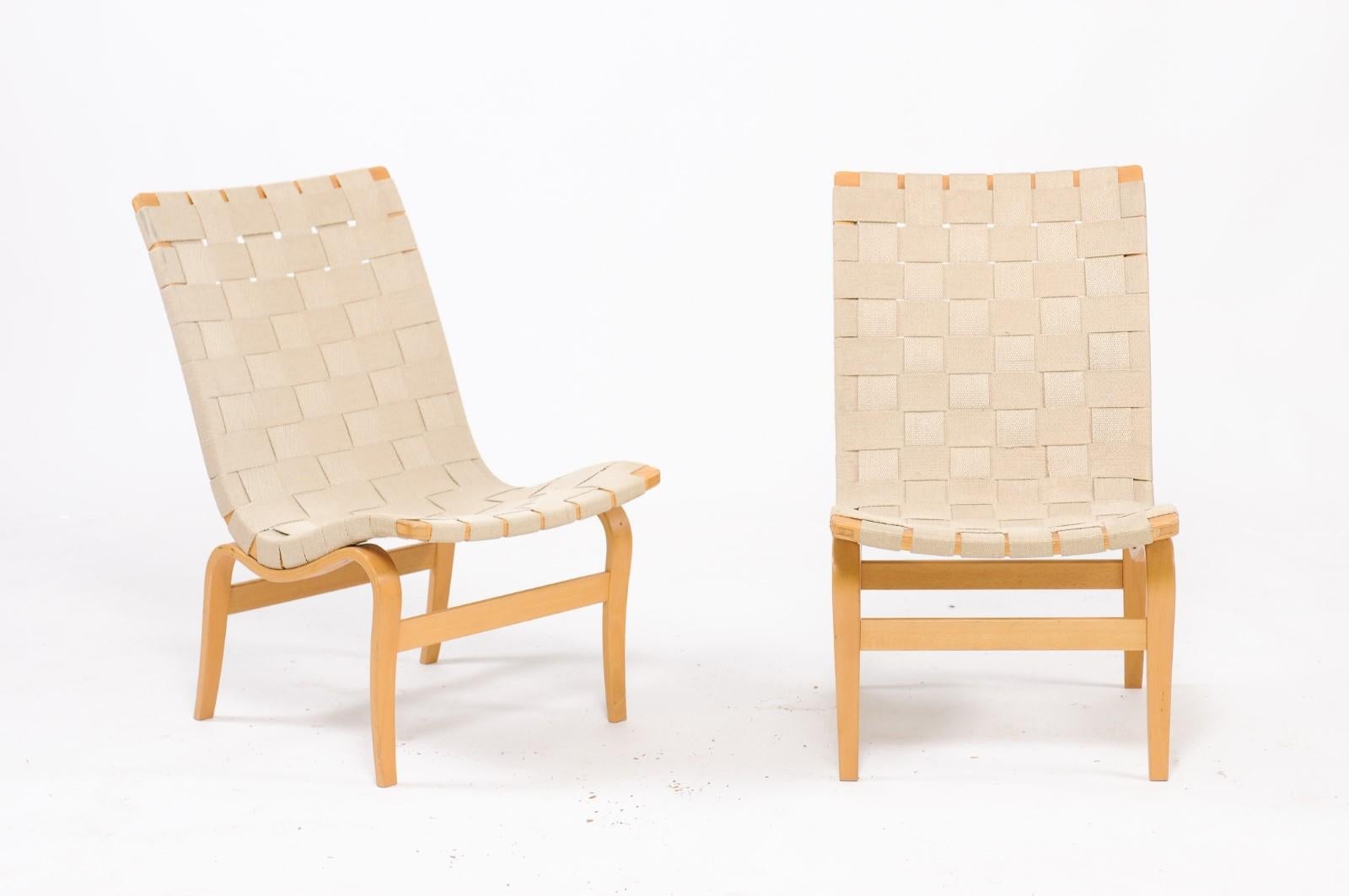 A pair of signed Bruno Mathsson for DUX armless Eva chairs made from bent birch and canvas strapping that will transform a space with Scandinavian Modern charm. 

Signed.