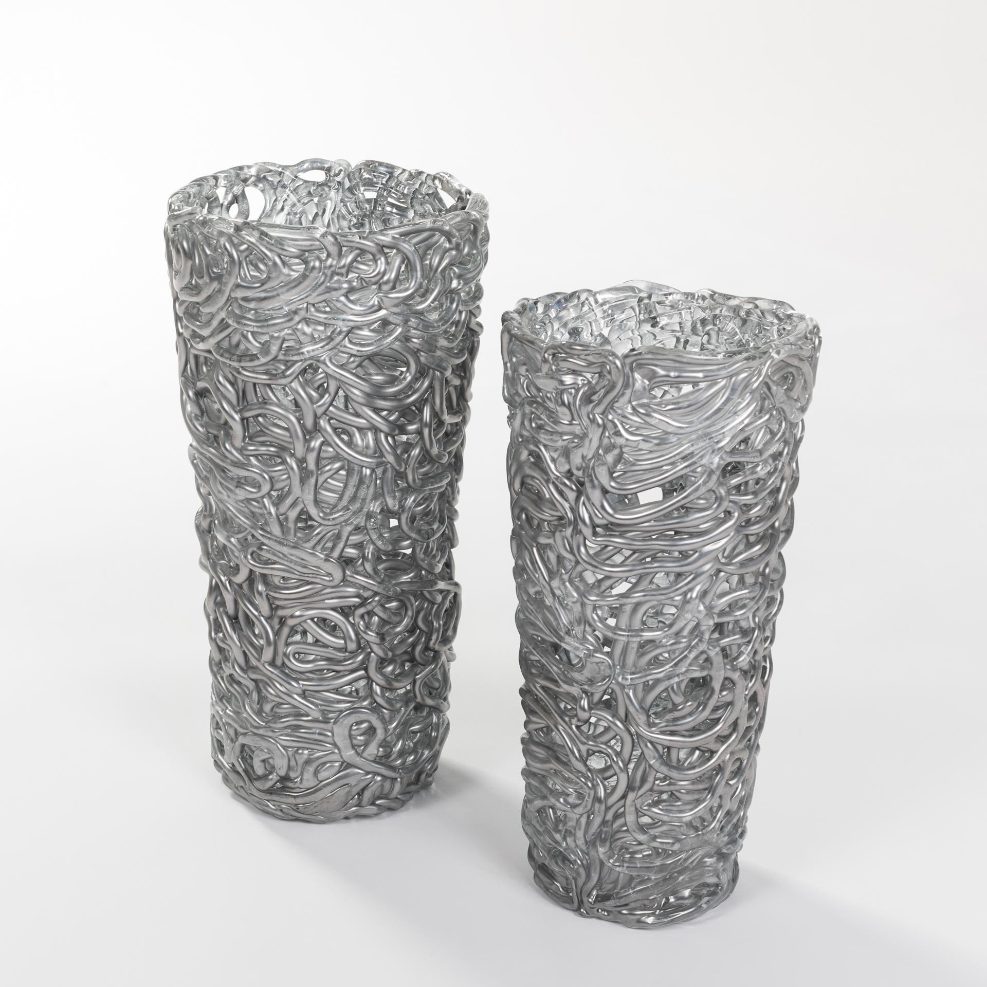 Exceptional pair of silver-colored Murano glass vases.
Intertwined glass veins shape the outer wall.
There is little space between the glass veins
Undamaged original condition.
Size 1: height 44cm x diameter above 22cm x diameter below 16cm
Size 2: