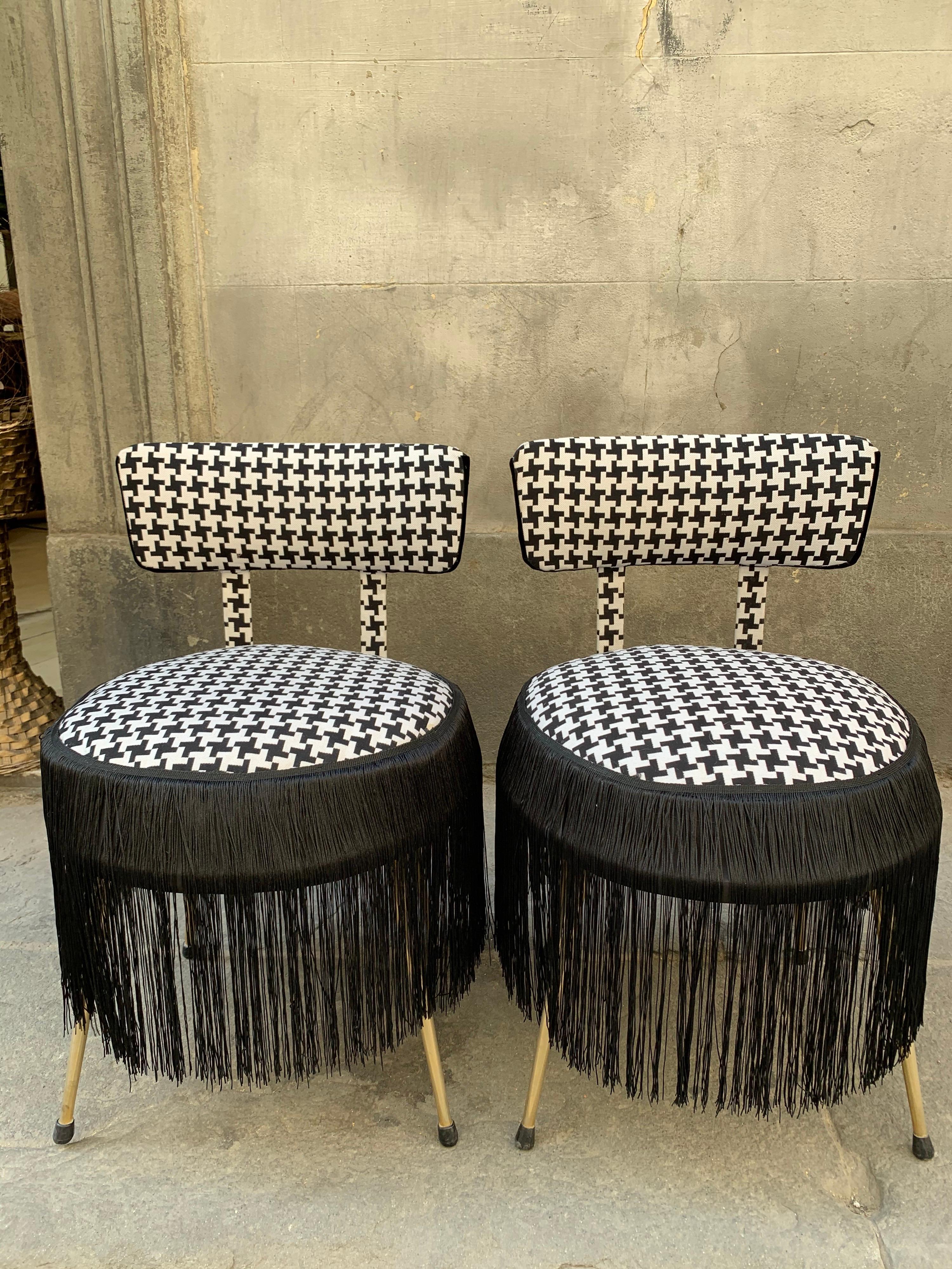 Pair of midcentury small padded chairs Houndstooth fabric with black fringe.
The chairs are newly upholstered with Houndstooth fabric (Pied de Poule) by Dedar.
Golden brass legs.