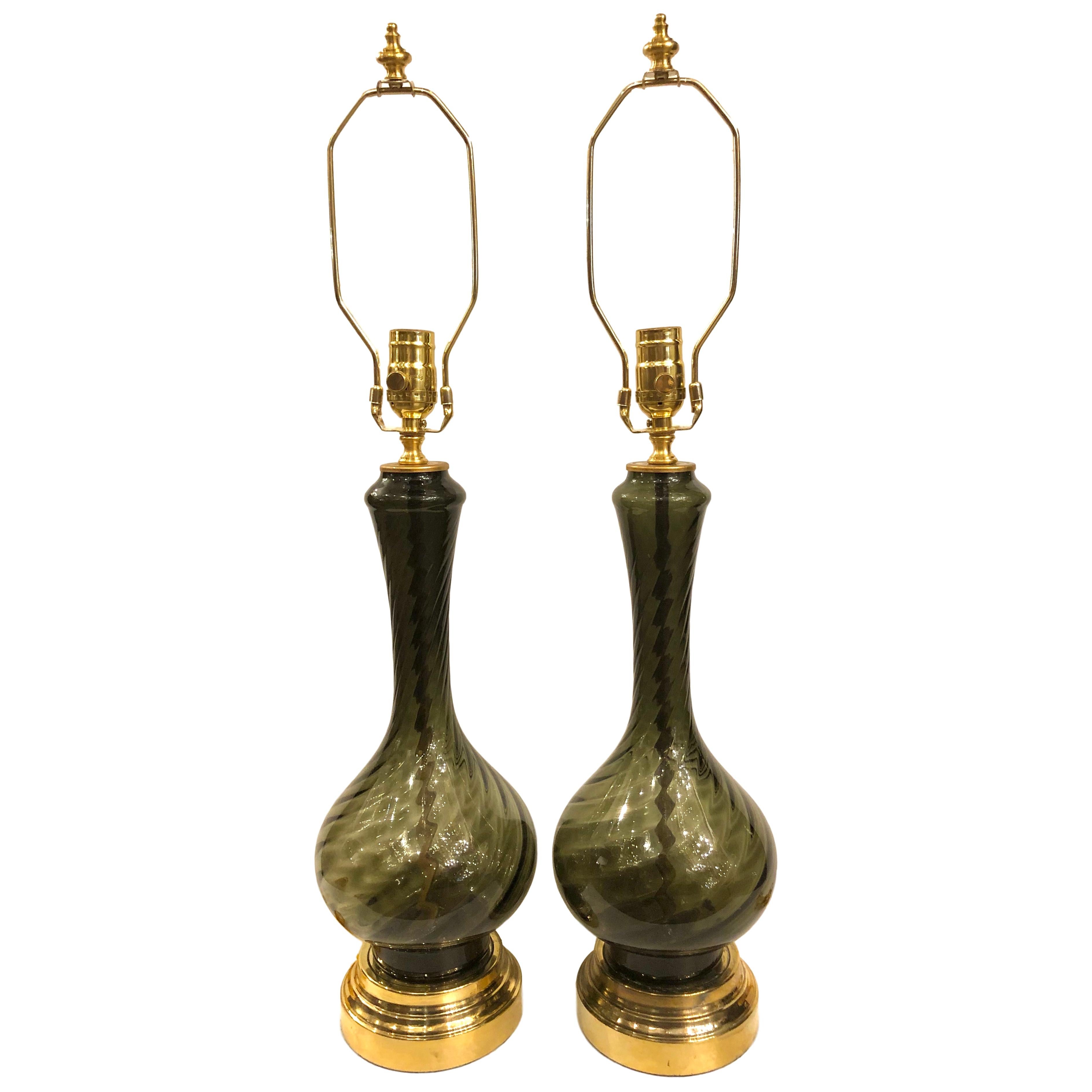 Pair of circa 1960s French smoke glass table lamps with twisting texture and gilt bases.

Measurements:
Height of body 17.5?
Height to shade rest 27?
Diameter at widest 7?.