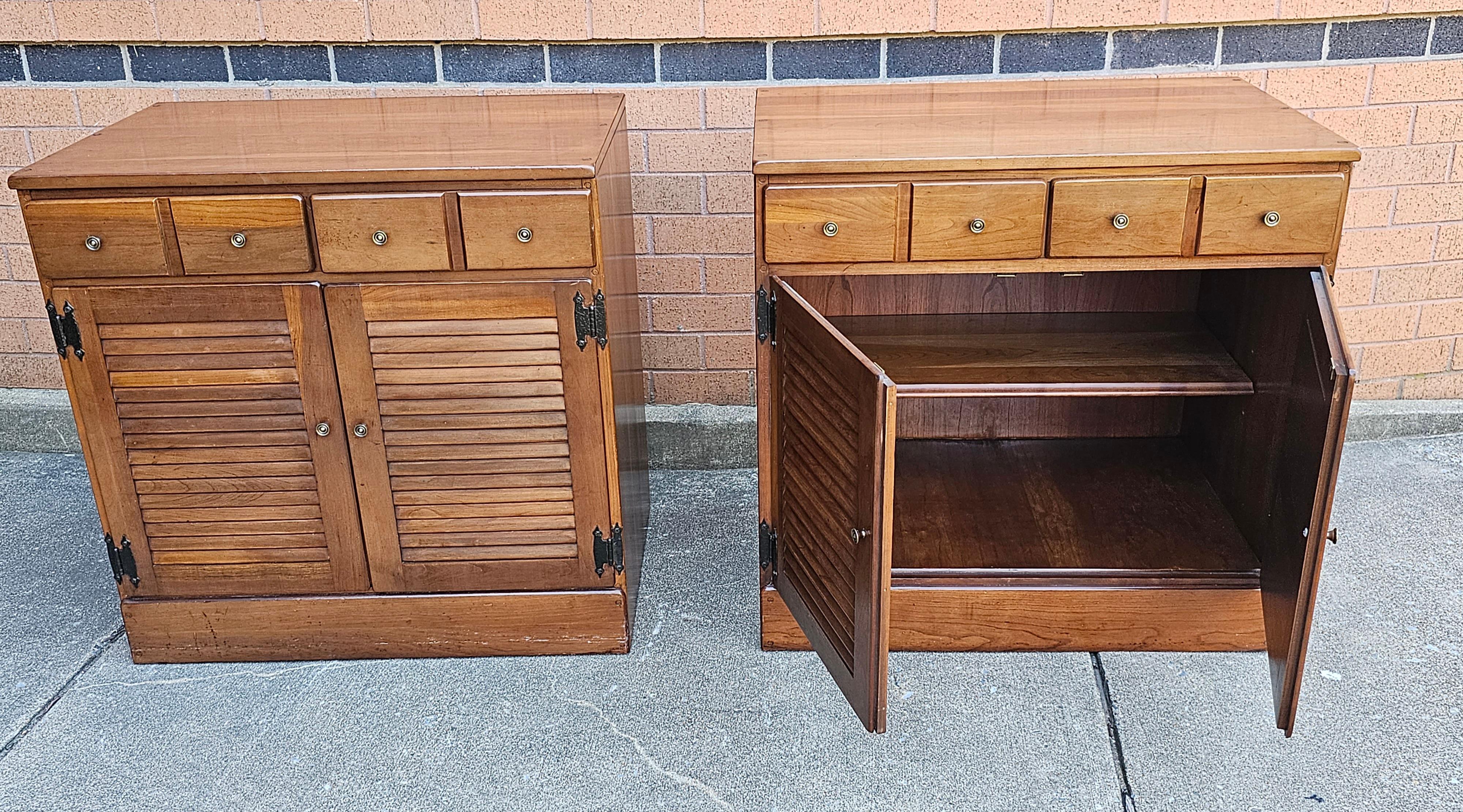Pair of Mid-Century Solid Cherry Side Cabinets, Circa 1970s. Features two top drawers and large double door storage cabinet with and an adhustable height shelf. Wood backing. Measures 30