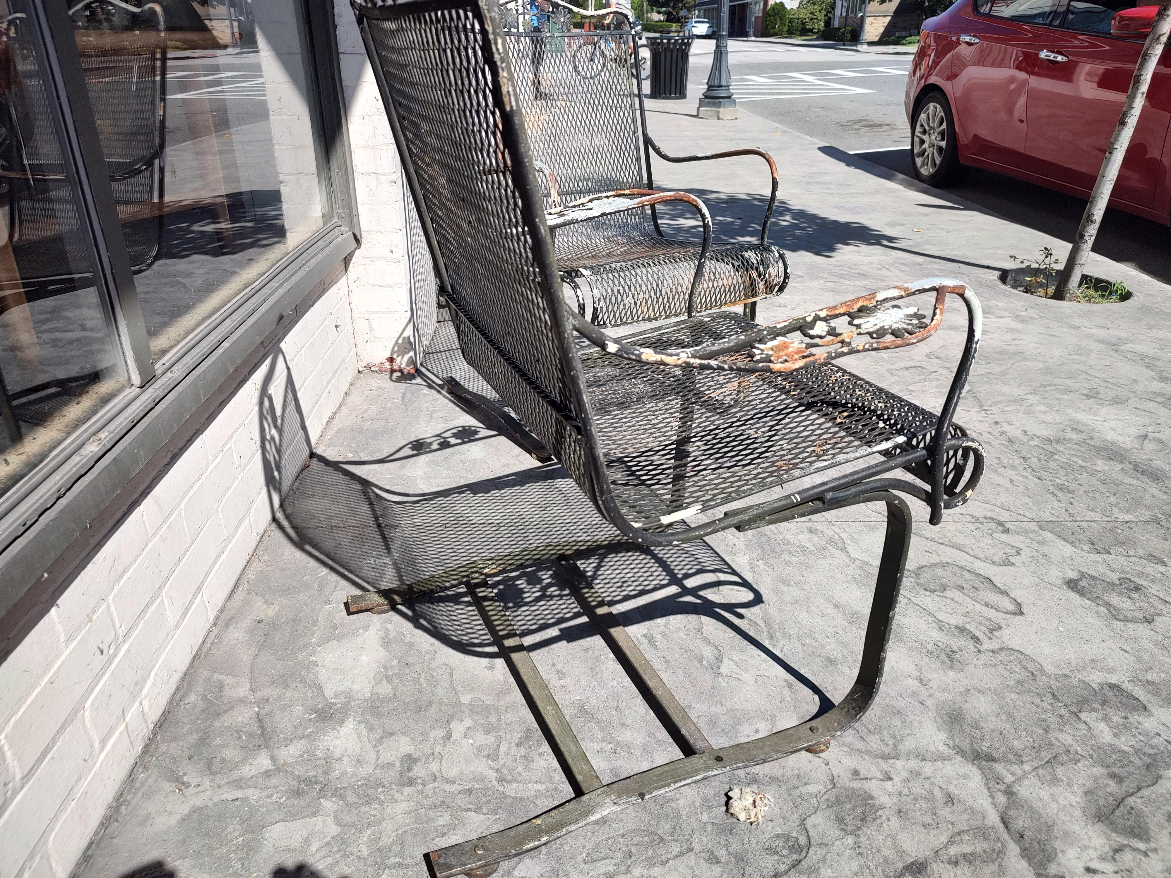 Fabulous pair of Woodard steel mesh bouncer spring chairs. Lots of patina. Floral decorations on the arms and back. So comfy and that spring! In excellent vintage condition with some surface rust.