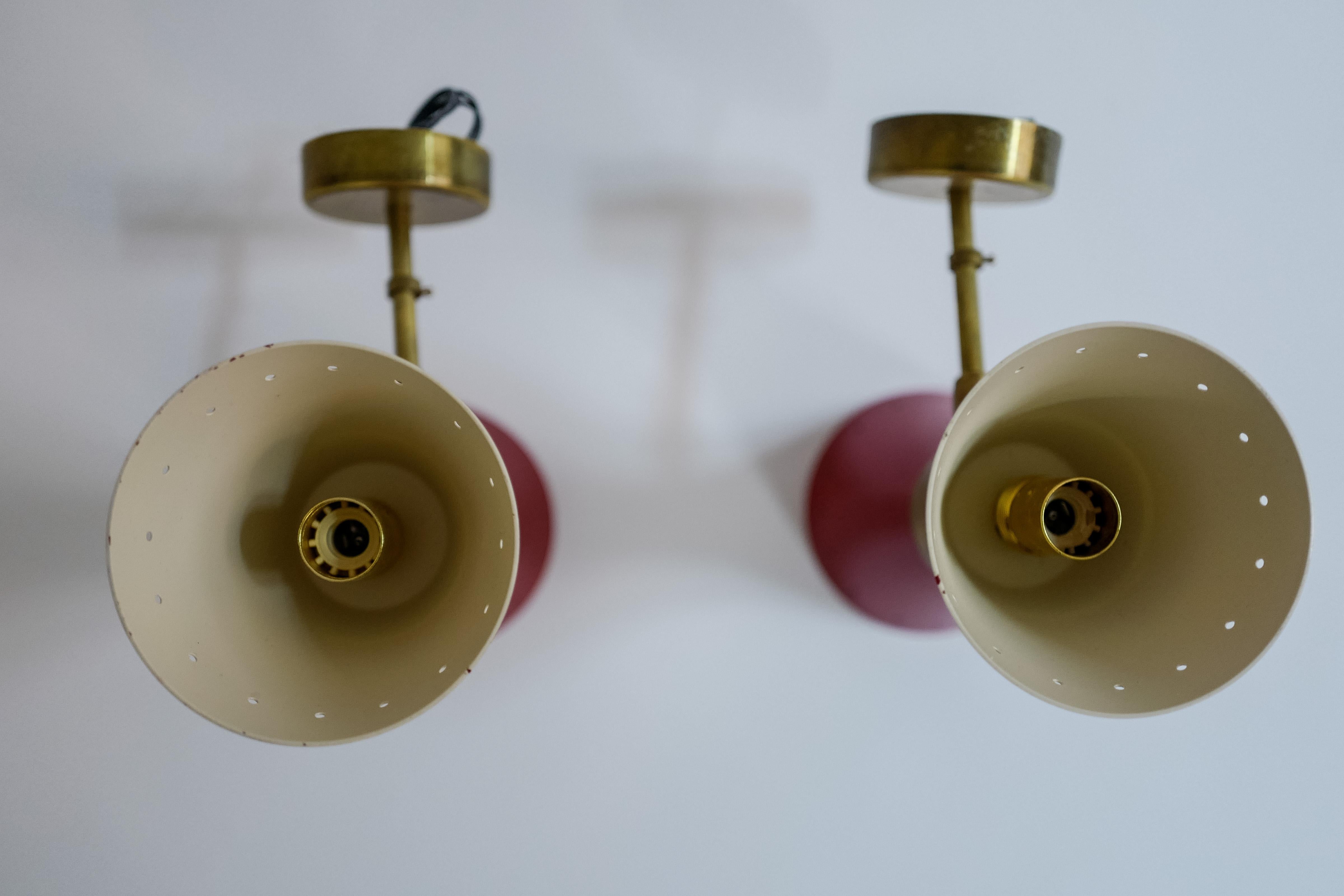 A fun vintage pair of mid century Stilnovo model Diabolo painted red metal and brass wall sconces, 1960’s Italy. Wired for Europe.