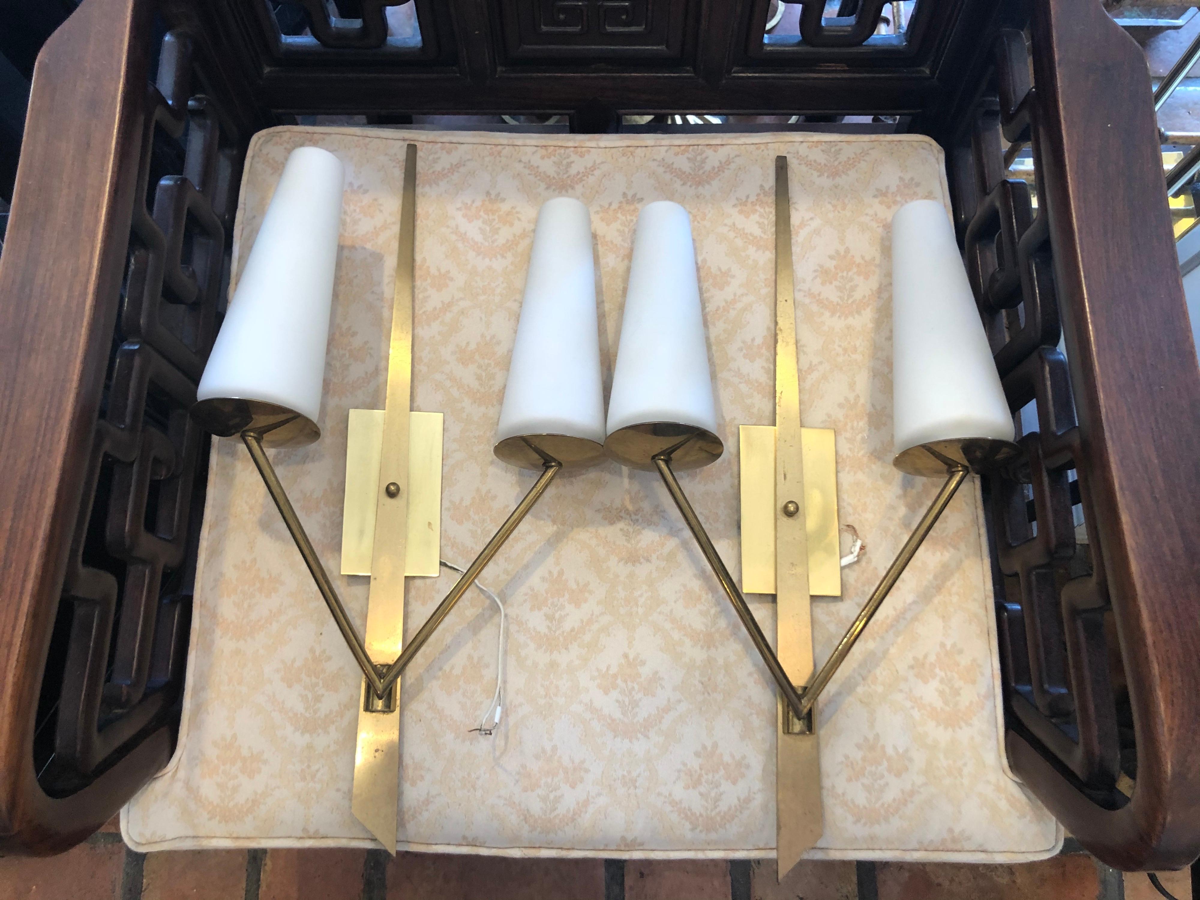 Pair of Mid Century Maison Arlus Sconces .Circa 1950. Minimalist brass with white glass shades. Classic timeless style. This price is for the pair/ 2. $2800 total. 
This item can parcel ship for $29.
Manufacturer	Arlus
Design and Production