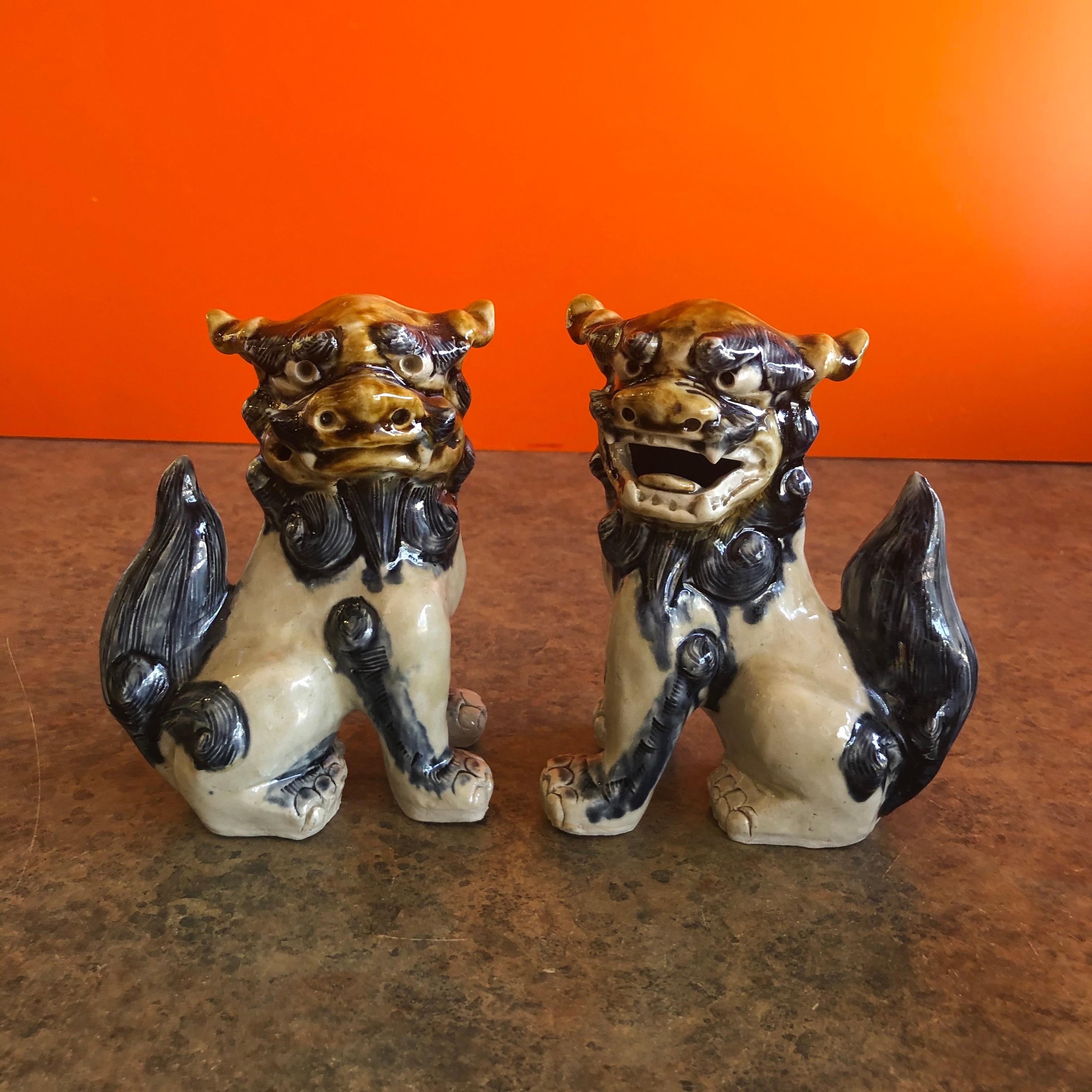 A very nice pair of vintage tan, cream and blue foo dogs, circa 1970s. Excellent condition and patina; the pair is made of pottery and would make great bookends or a fun decor item in any room! #1162.