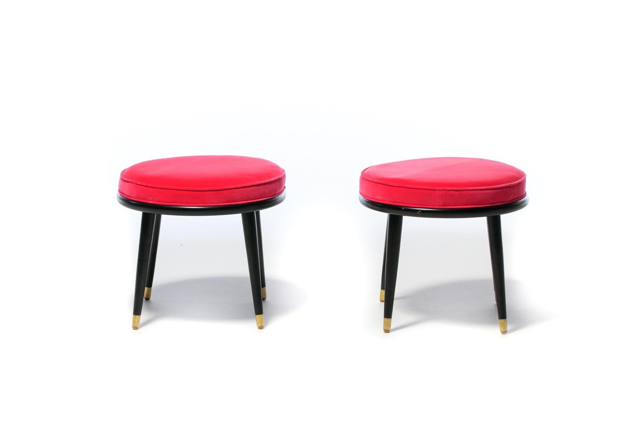 Pair of mid century round stools with tapered dark walnut legs and brass sabots. Hot pink velvet upholstery. A color associated with fashion designer Schiaparelli's signature Shocking Pink. Useful size that could be placed fireside or floating in a