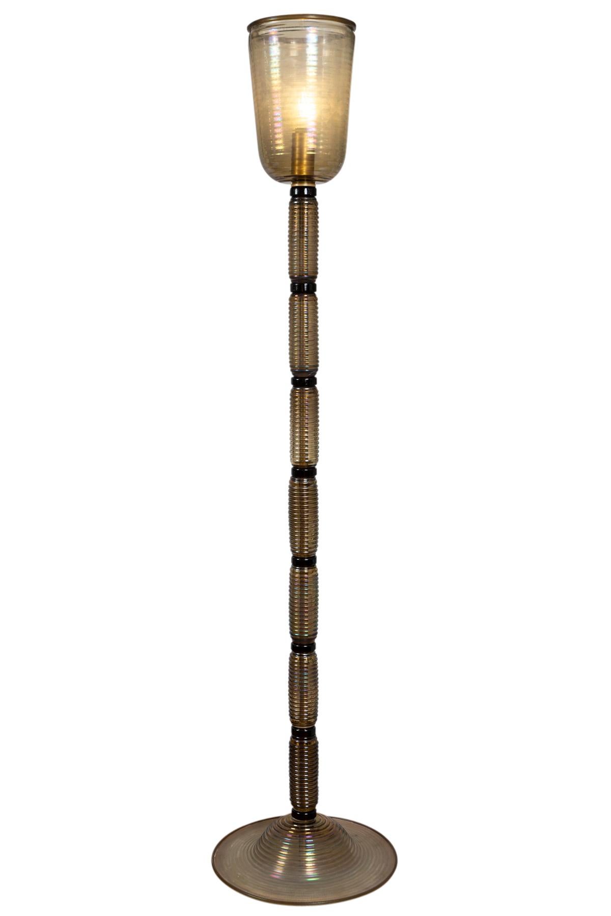 Venini style smoke beige blown glass with irridescence form this minimilistic torchiere floor lamp comprised of 17 glass pieces of glass.

Origin: Murano, Italy
Dating: Contemporary, Artisan Blown Work
Dimensions: 77? high, 17? diameter.