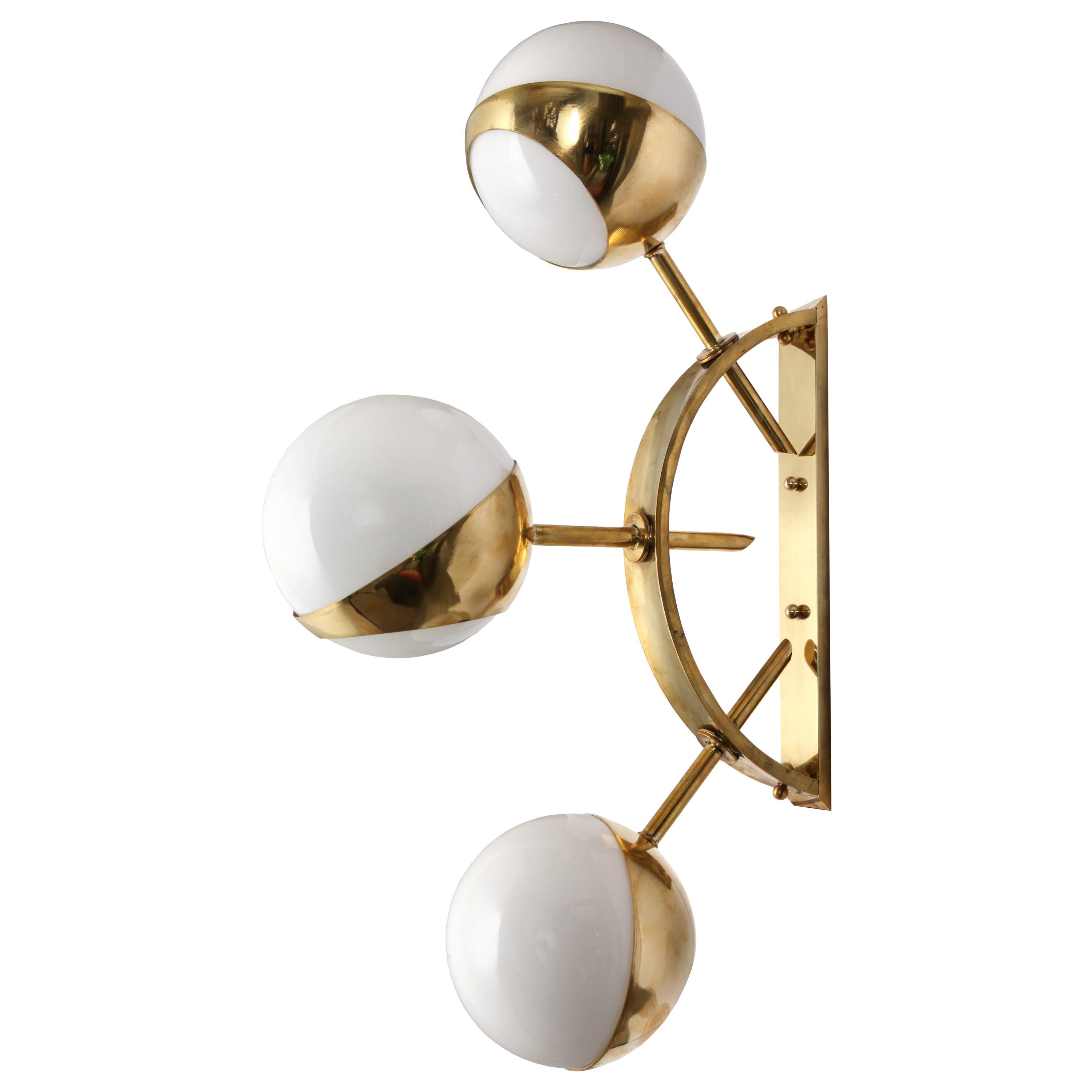 A semi-circular brass-mounted wall light with three opal shades in the style of Stilnovo. The brass is un-lacquered and left natural which means over time it will take on an aged patina, but can be polished to a shine. 

Wired for EU, each sconce