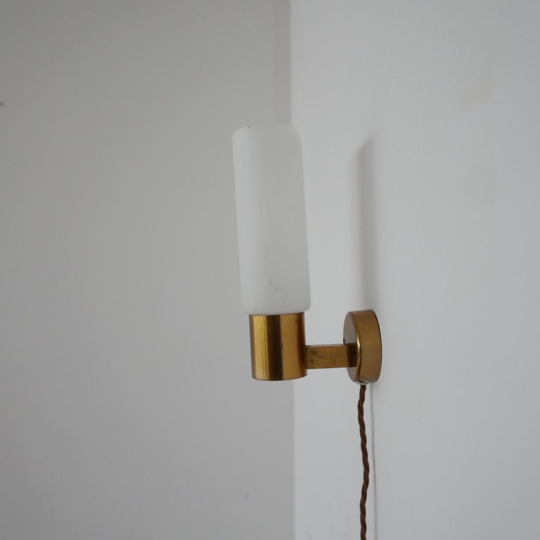 A pair of midcentury wall lights. 

Sweden, c1970s. 

Re-wired with gold silk flex. 

Brass gallery with sandblasted glass shades. 

Price is for the pair. 

Dimensions: 22 H x 7 W x 12.5 D in cm.
  