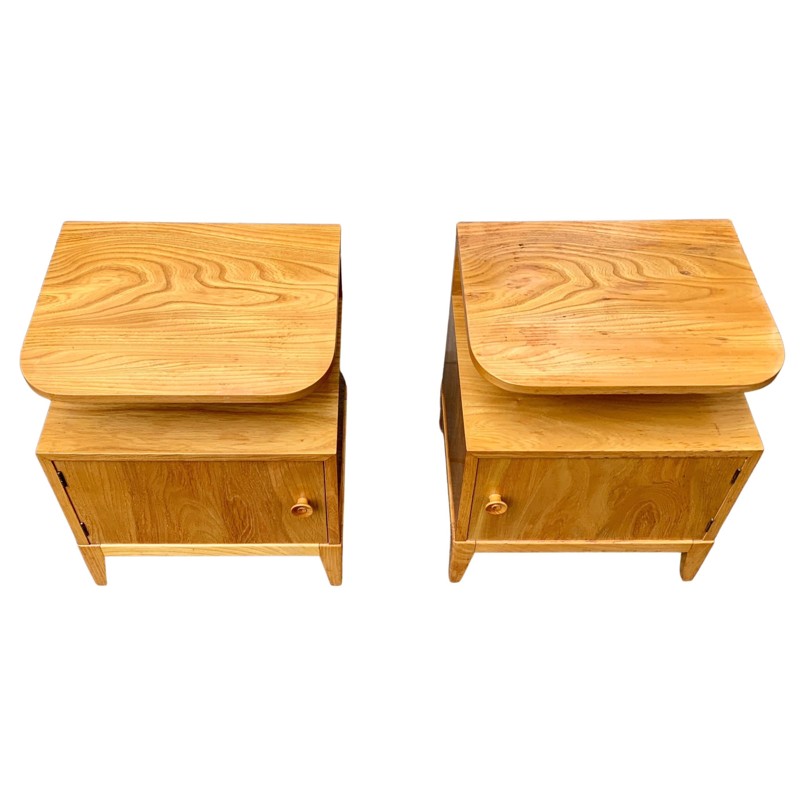 A pair of Swedish nightstands or small night tables in elm and oak wood with the original wooden handles and a shelf on top.
This set is a honest pair, meaning that the set has left and right facing doors the cabinets. They were recently bought in