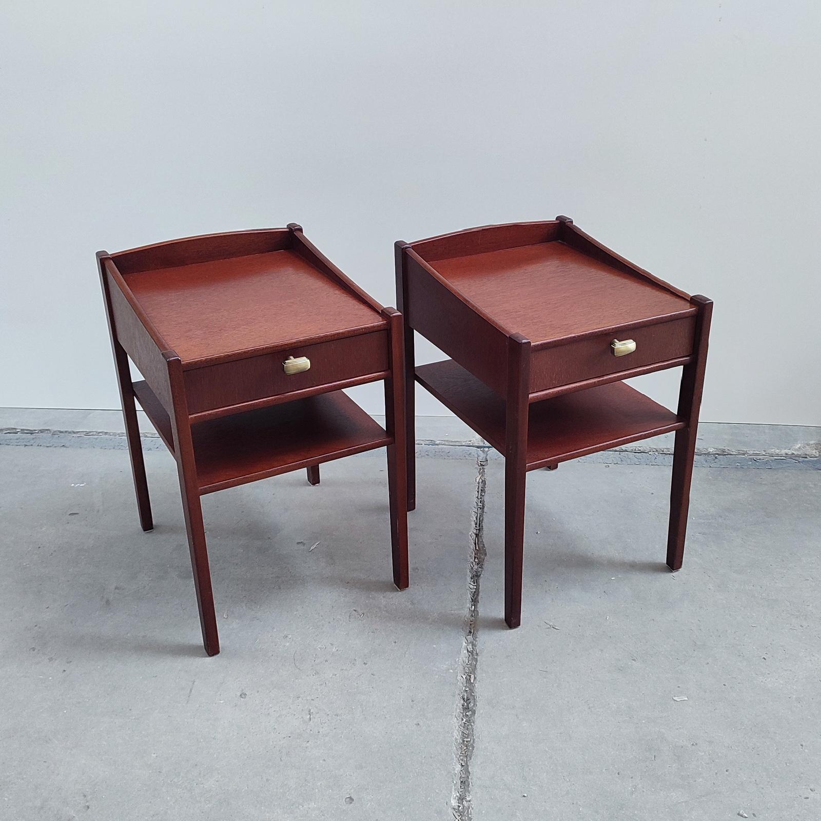 A pair of mahogany nightstands or side tables with top drawer and lower shelf.
Asymmetric sides, resembling in design to Kerstin Horlin Holmquist's furniture pieces. In good overall condition, normal wear and few tears. They have been