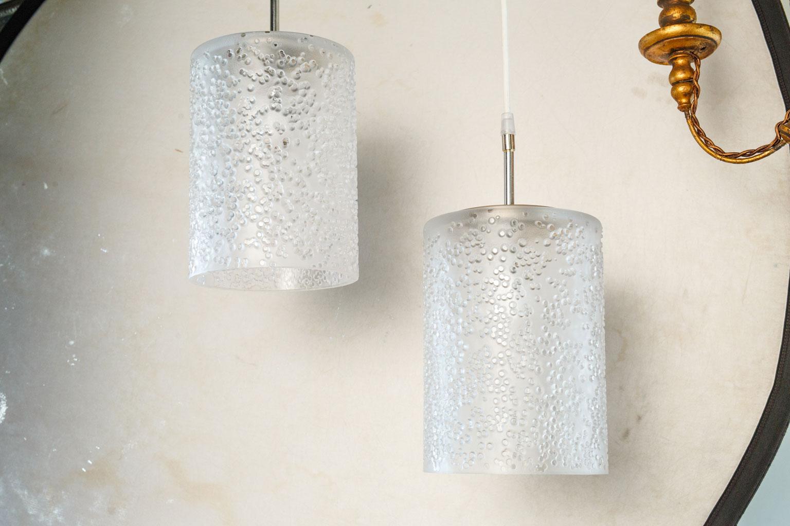 Pair of midcentury Swedish pendants in semi-transparent frosted glass. These modern cylinder shaped lights each accommodating a medium-size base (Edison) down-turned bulb. Newly wired for use within the USA. Includes canopies. These pendants are