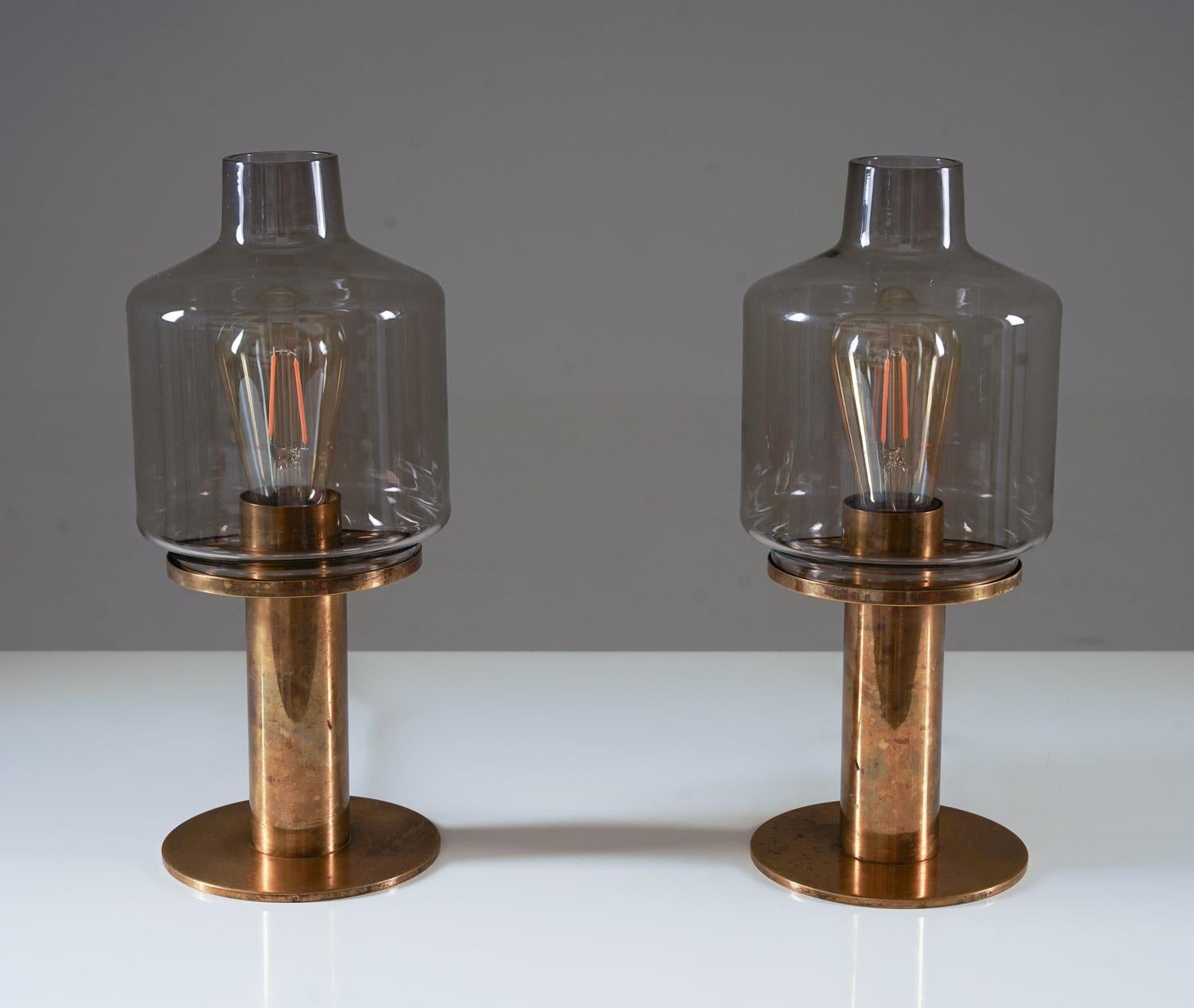 A pair of magnificent table lamps by Hans-Agne Jakobsson for Hans-Agne Jakobsson, Markaryd, Sweden.
The lamps consist of a heavy brass base, holding the smoke-coloured shades.

Condition: The lamps are good condition, with patina on the brass;