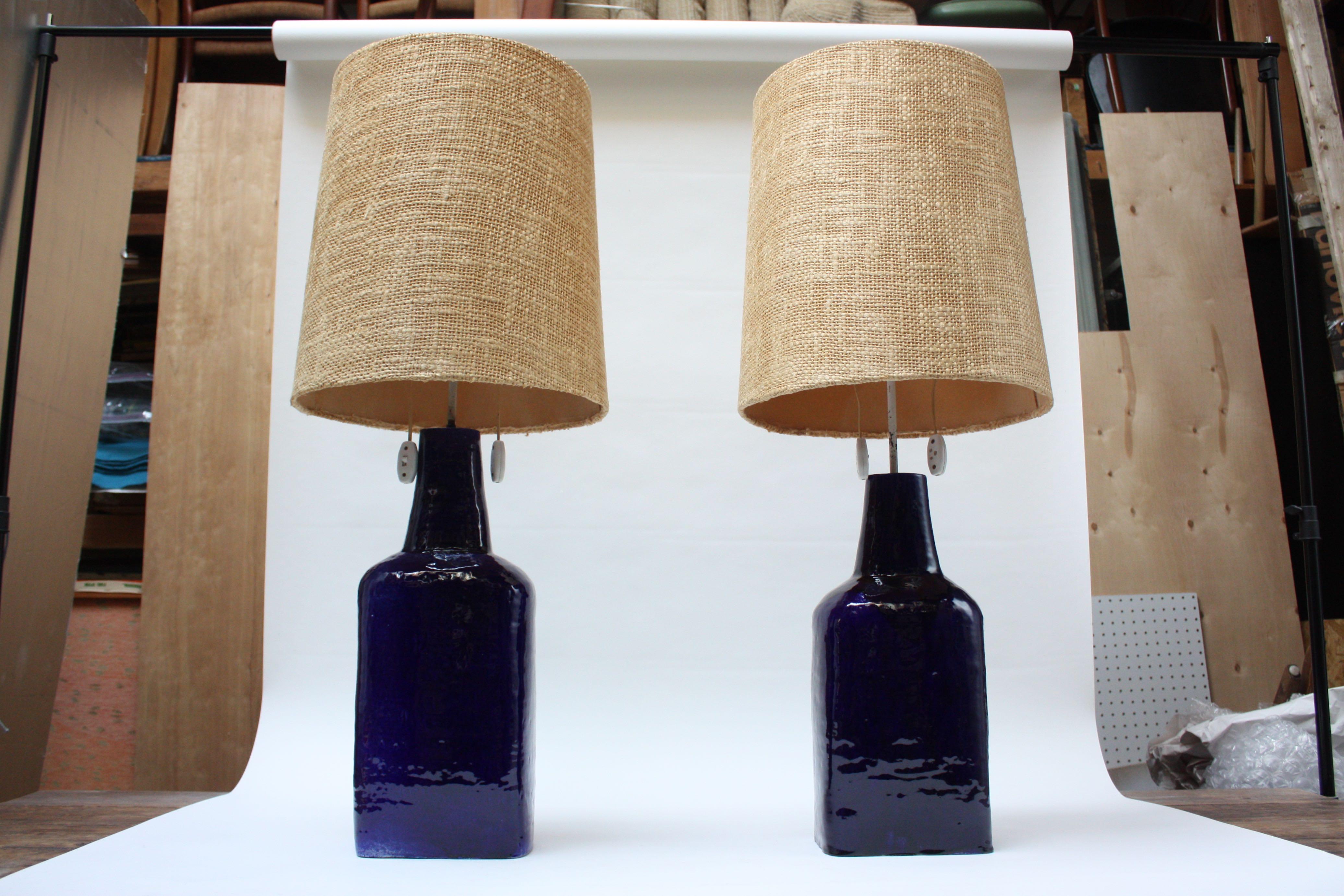 Außergewöhnliches und seltenes Paar großer Keramik-Tischlampen des Schweizer Keramikers Mattli (um 1960). Bestehend aus Terrakotta-Böden mit einer hochglänzenden indigoblauen Glasur. Verfügt über zwei Steckdosen und große konische Diffusoren mit