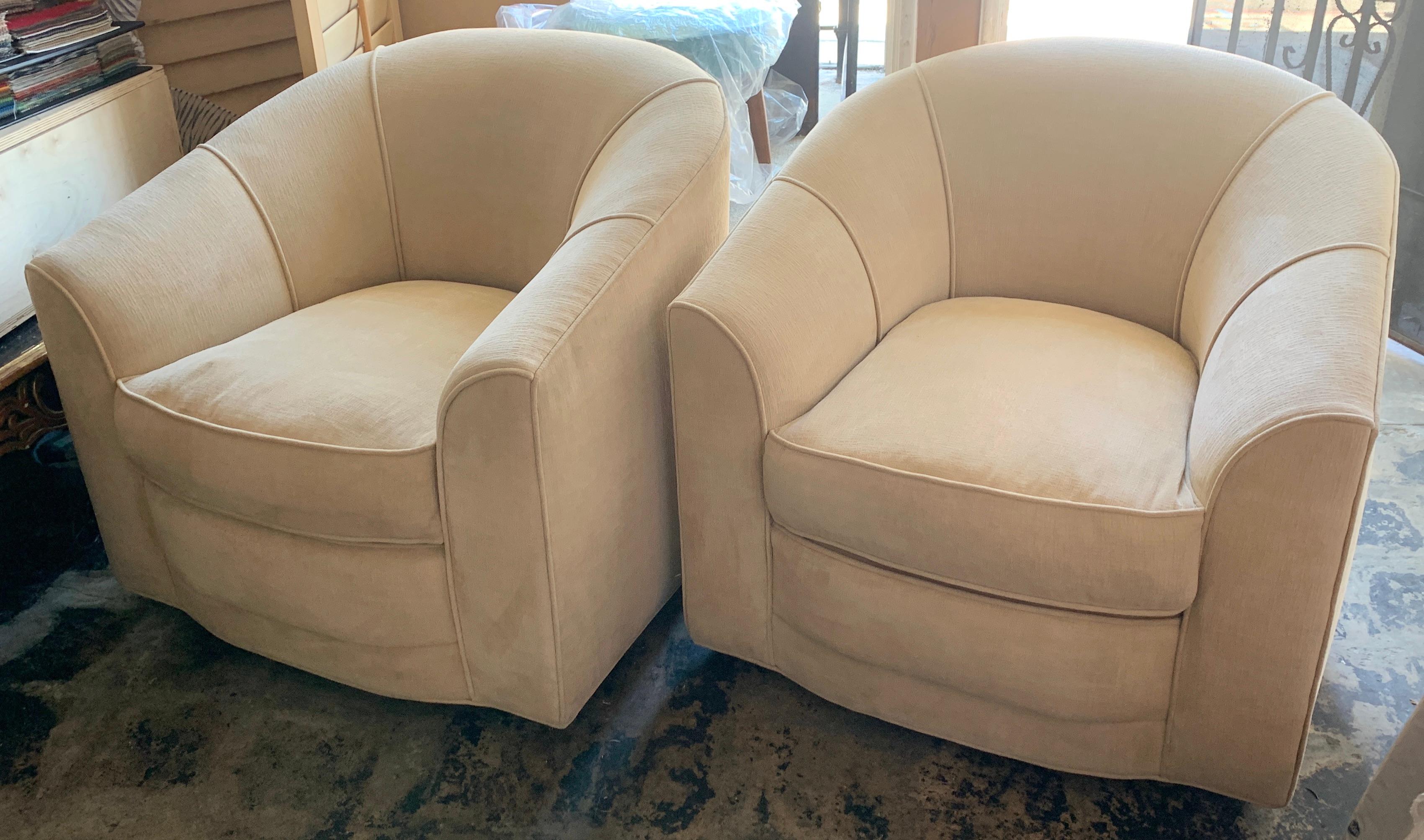 Pair of mid century swivel club chairs in the style of Milo Baughman - Cream upholstery looks to be original and in very good condition. Large and comfortable the swivel makes them well suited for any room, especially a den or bedroom.