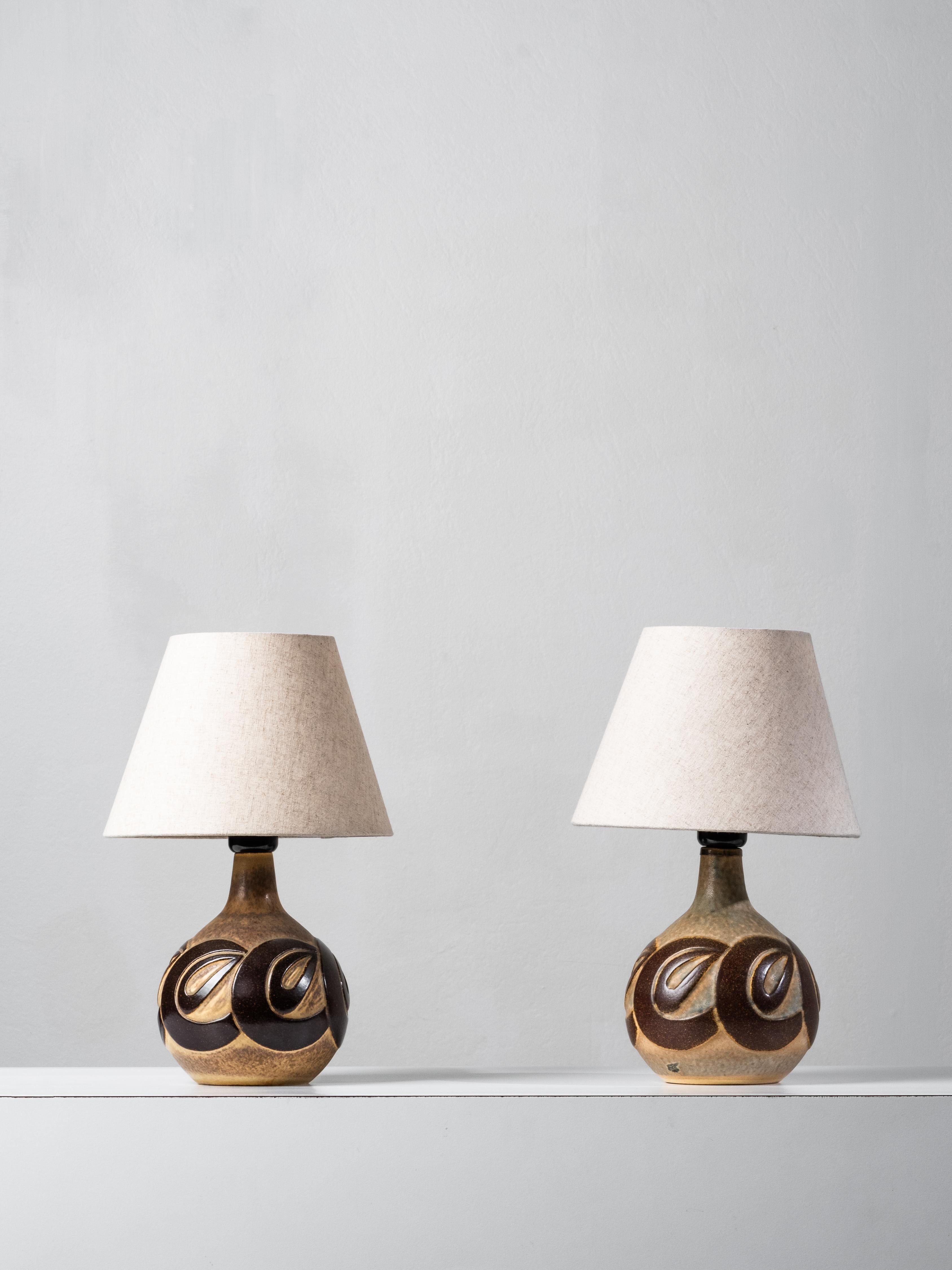 Coppia di lampade da tavolo in gres danese della metà del secolo scorso disegnate da Marianne Starck per Michael Andersen & Søn, Bornholm. Model No. 6399. Ogni lampada è realizzata a mano e smaltata nei toni del marrone e dell'ocra, con un sottile