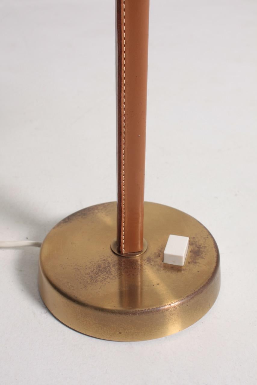 Paire de lampes de table recouvertes de cuir patiné sur une base ronde en laiton. Conçu et fabriqué en Suède dans les années 1950. Excellent état.
