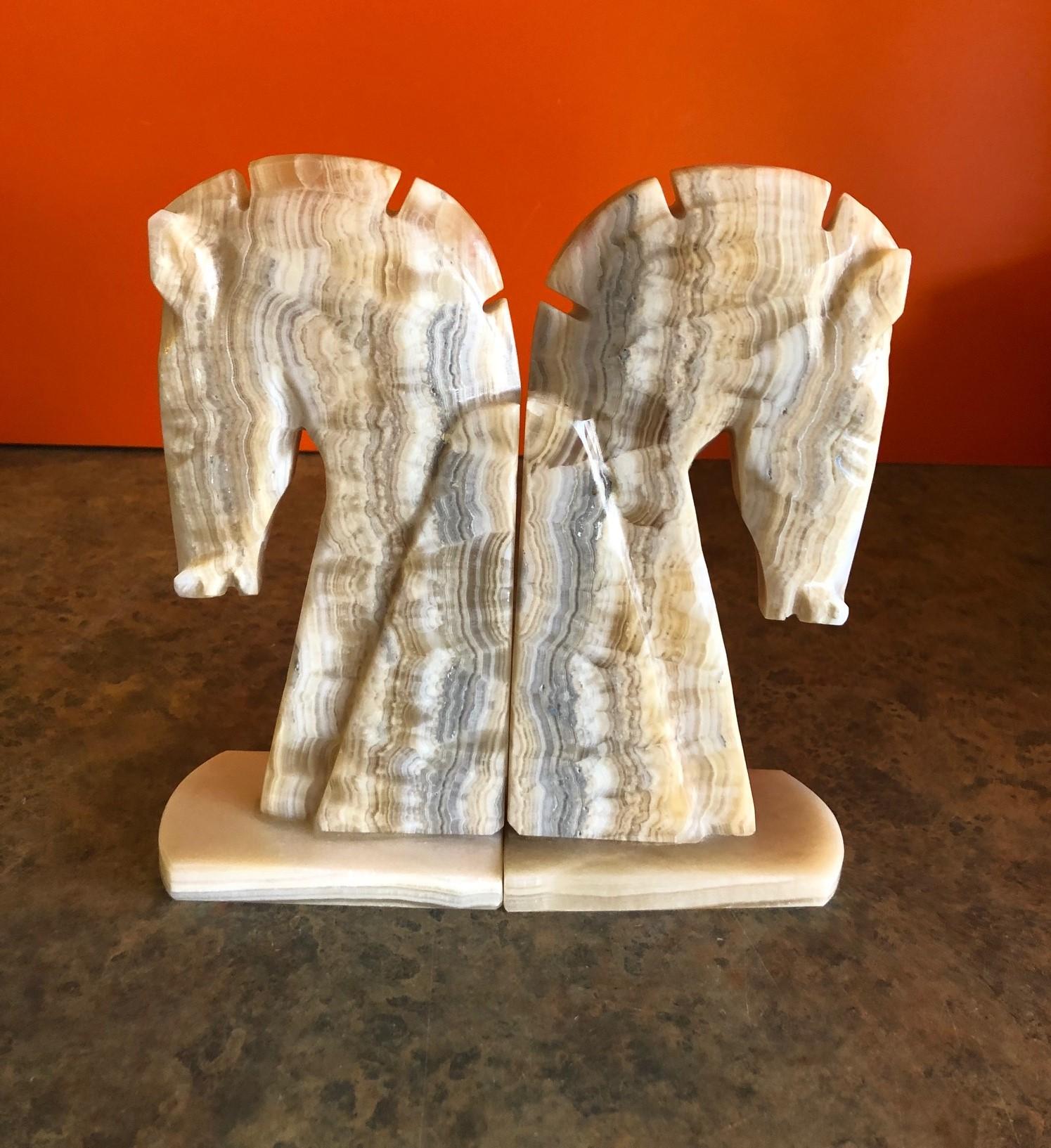 Very stylish pair of midcentury tan / grey marble horse head bookends, circa 1970s. The bookends are heavy and solid and well crafted. They would make a great addition to any office or den.