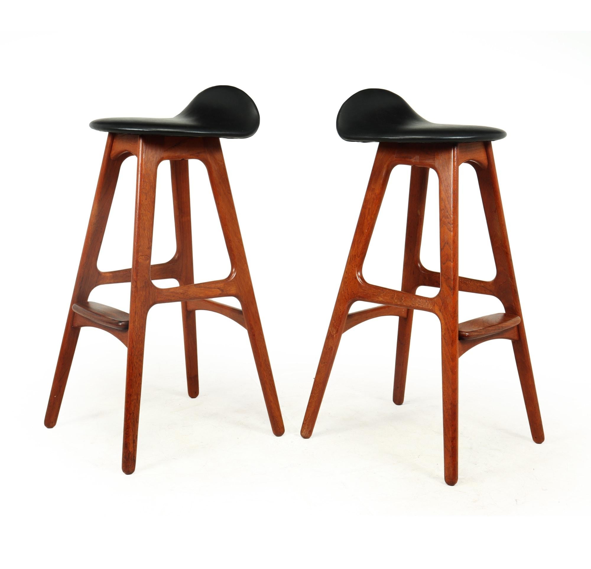 A pair of Iconic stools in teak and leather by Danish designer Erik Buck and produced by Oddense Møbelfabrik in Denmark in the mid 1960’s, they have black leather seats solid teak frame with rosewood footrests, the seats have been re upholstered in