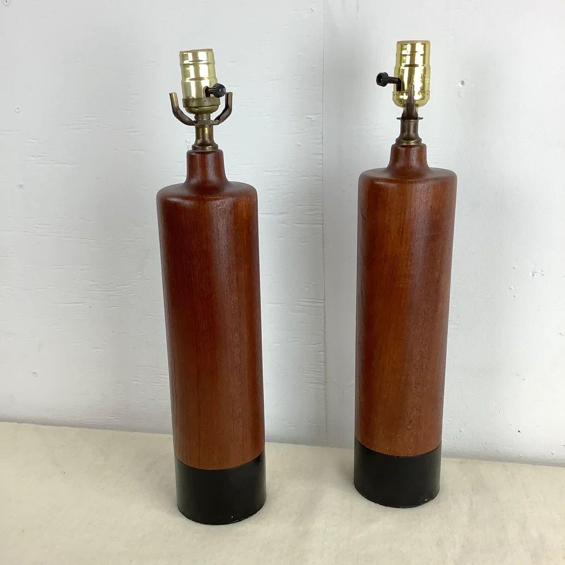 This striking pair of Danish Modern turned teak table lamps from ESA of Denmark add simple yet striking Scandinavian style to any interior in need of a matching pair of lamps. This circa 1960s pair of lamps showcases wonderful natural teak finish