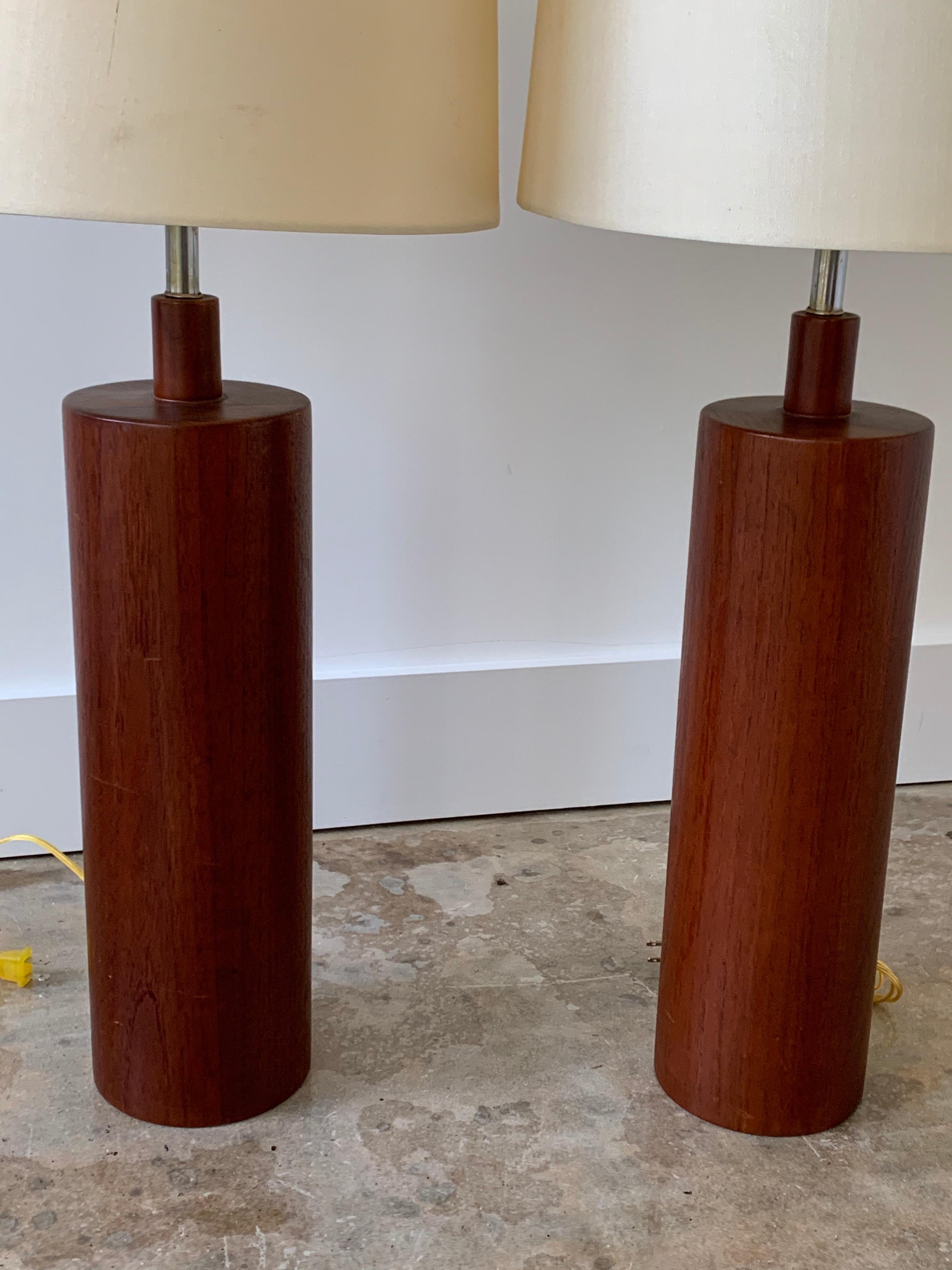 Pair of solid teak lamps of imposing scale.