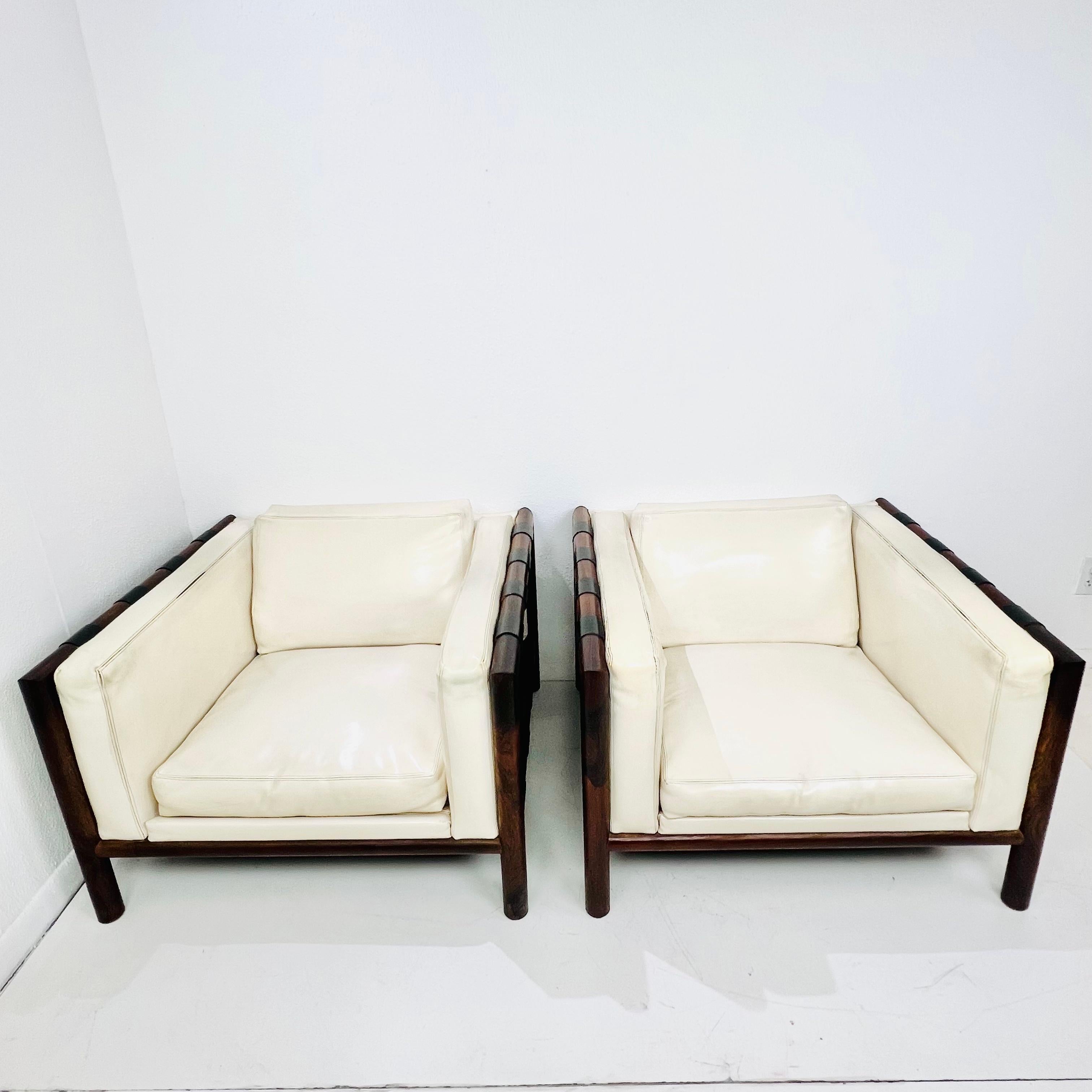 Paire de fauteuils de salon du milieu du siècle de Thayer, avec des cadres en bois de rose massif au grain organique, un rembourrage en Naugahyde d'origine et des sangles en cuir noir sur les côtés. Bon état structurel et général avec quelques