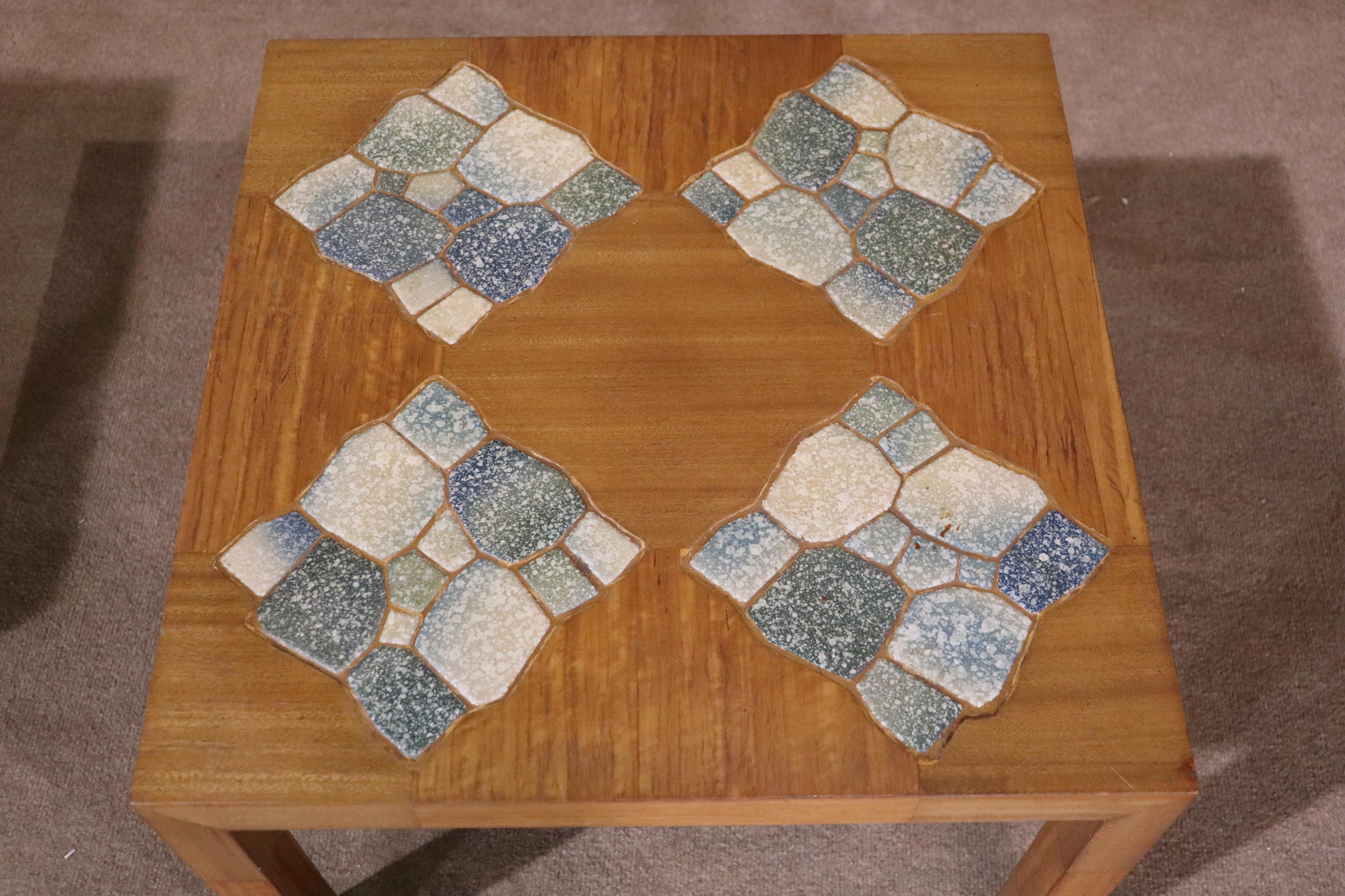 This pair of mid-century modern side tables feature inlay ceramic tiles. Four tile diamond shape mosaics set in a mahogany top.
Please confirm location NY or NJ 