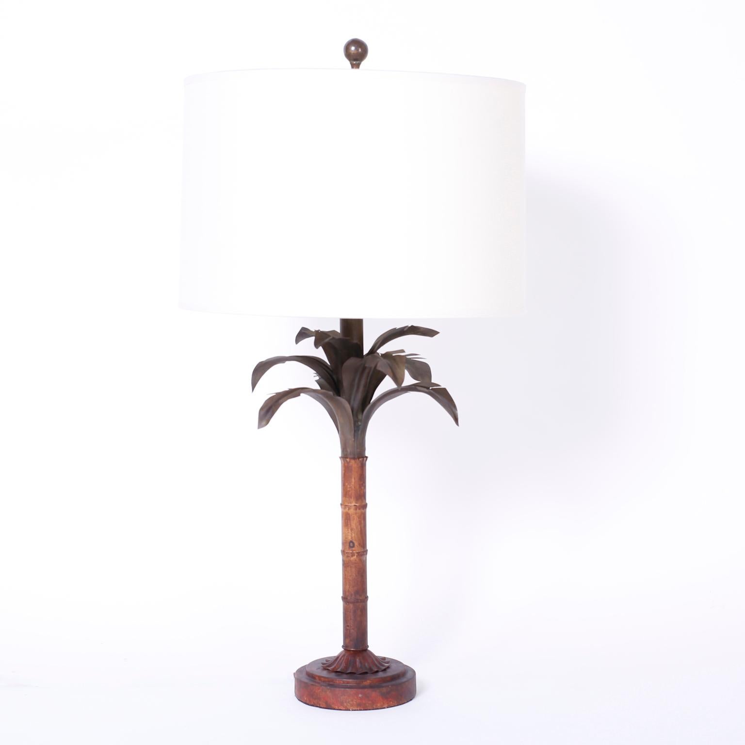 Pair of midcentury tole stylized palm tree table lamps painted in earthy colors and having dynamic decorative appeal.
