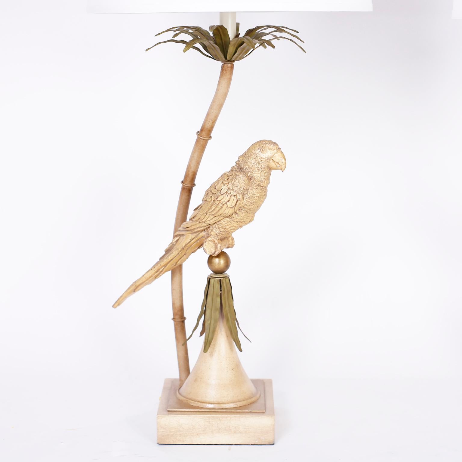 Whimsical pair of midcentury table lamps crafted in painted metal depicting cast metal gold painted parrots under a stylized tole palm tree.