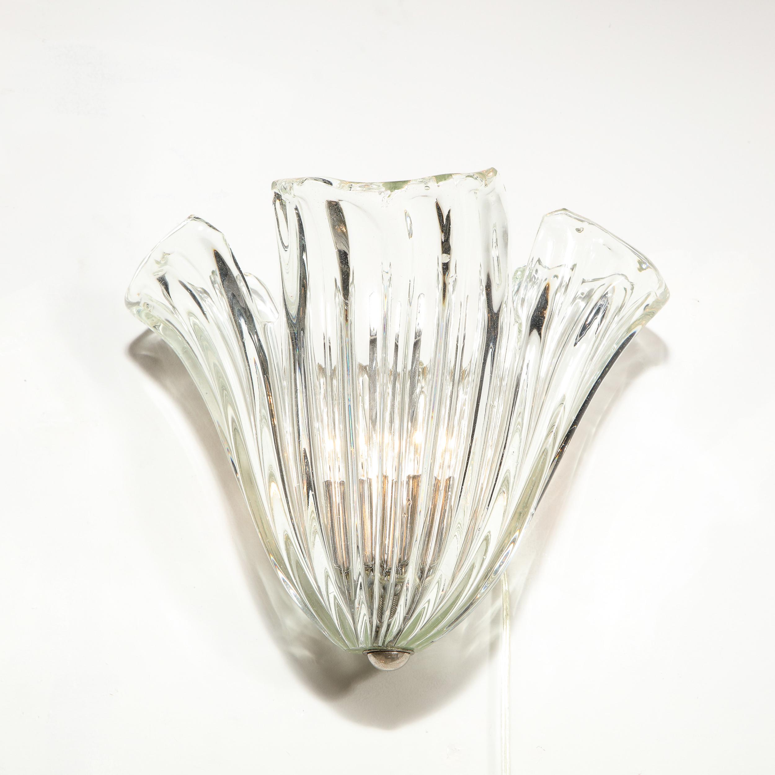 This stunning pair of Mid-Century Modern sconces were realized by the fabled Italian atelier of Barovier e Toso, circa 1950. They feature translucent channeled bodies that taper to their base, suggesting abstracted anemones, with stylized slits at