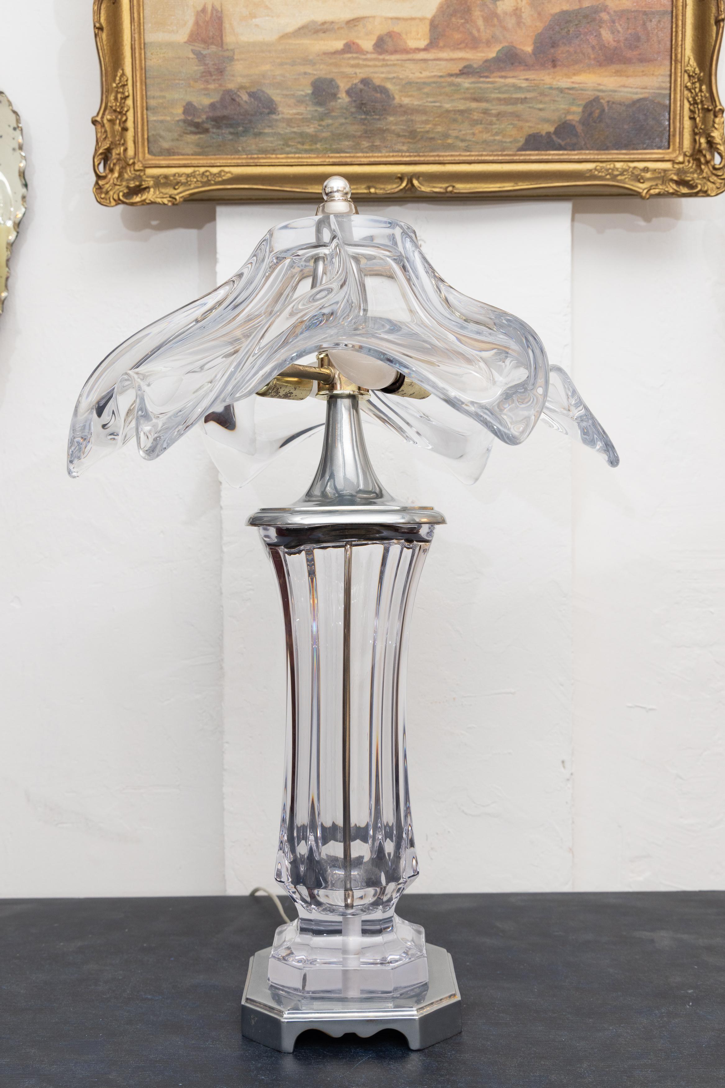 Si tratta di una coppia di lampade in vetro trasparente a forma di vaso uniche della metà del secolo scorso.  Il  Il paralume in vetro dalla forma artistica è fissato alla sezione inferiore da un'asta in metallo argentato e si trova su basi in