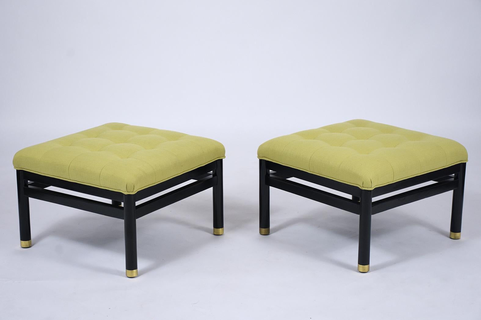 An eye-catching pair of midcentury tufted benches crafted out of mahogany wood with a newly ebonized lacquered finish has been fully restored by our expert team of professional craftsmen. The pair of ottomans are newly upholstered in a green color