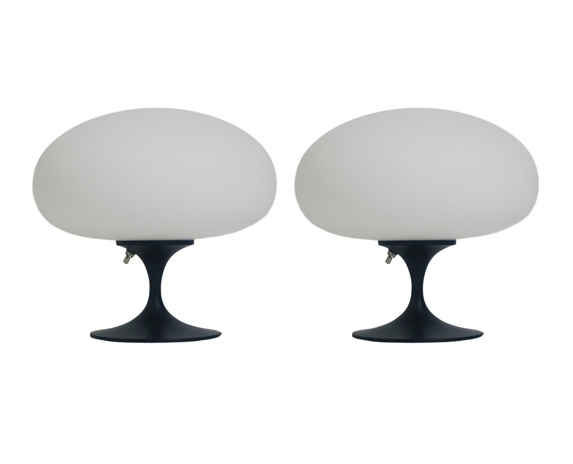 A gorgeous matching pair of tulip form table lamps after Laurel Lamp company. These feature black powder coated cast aluminum bases with mouth blown frosted white glass shades. The price includes the pair as shown.
