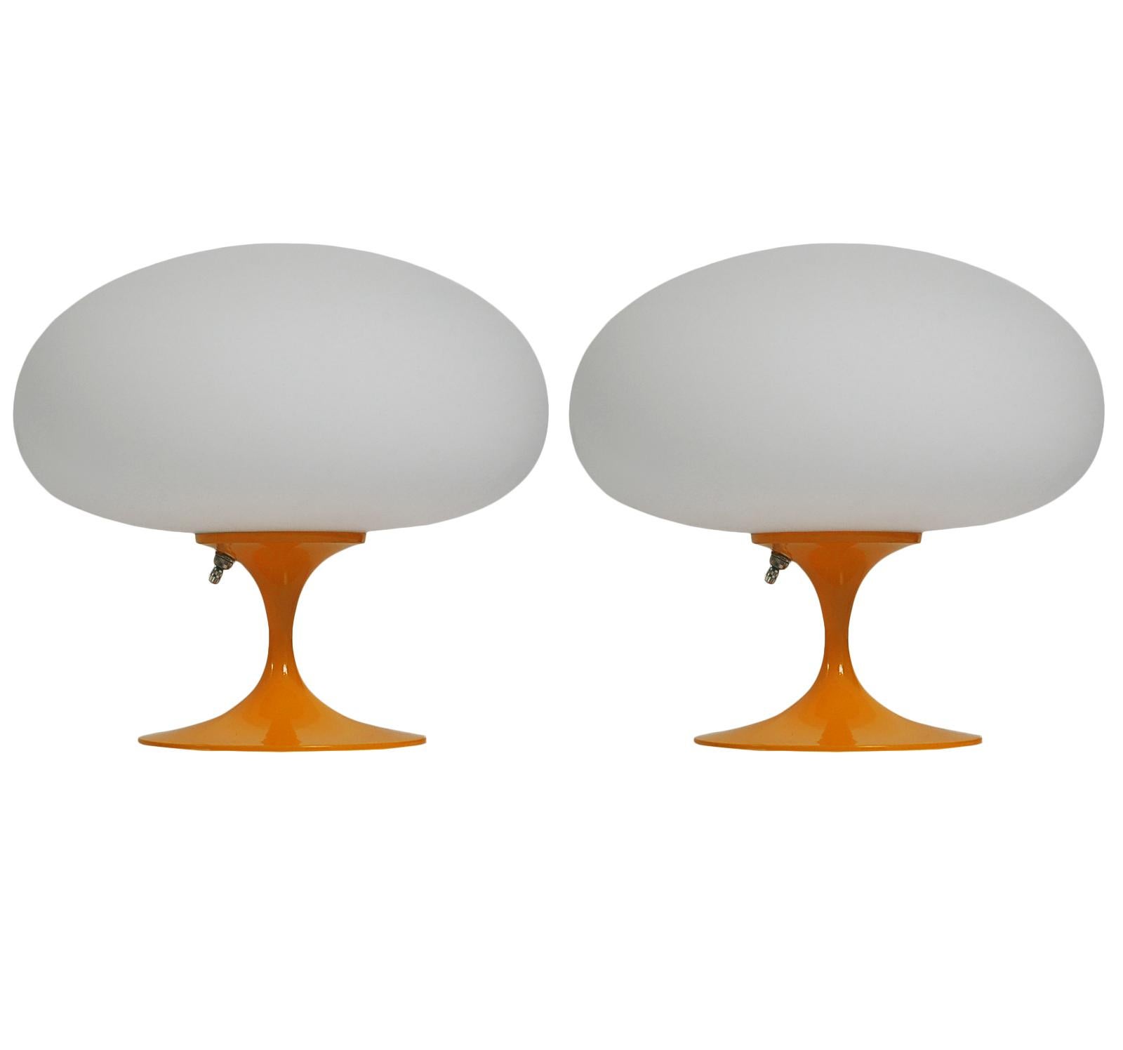 A gorgeous matching pair of tulip form table lamps after Laurel Lamp Company These feature an light mango orange powder coated cast aluminum bases with mouth blown frosted white glass shades. The price includes the pair as shown.