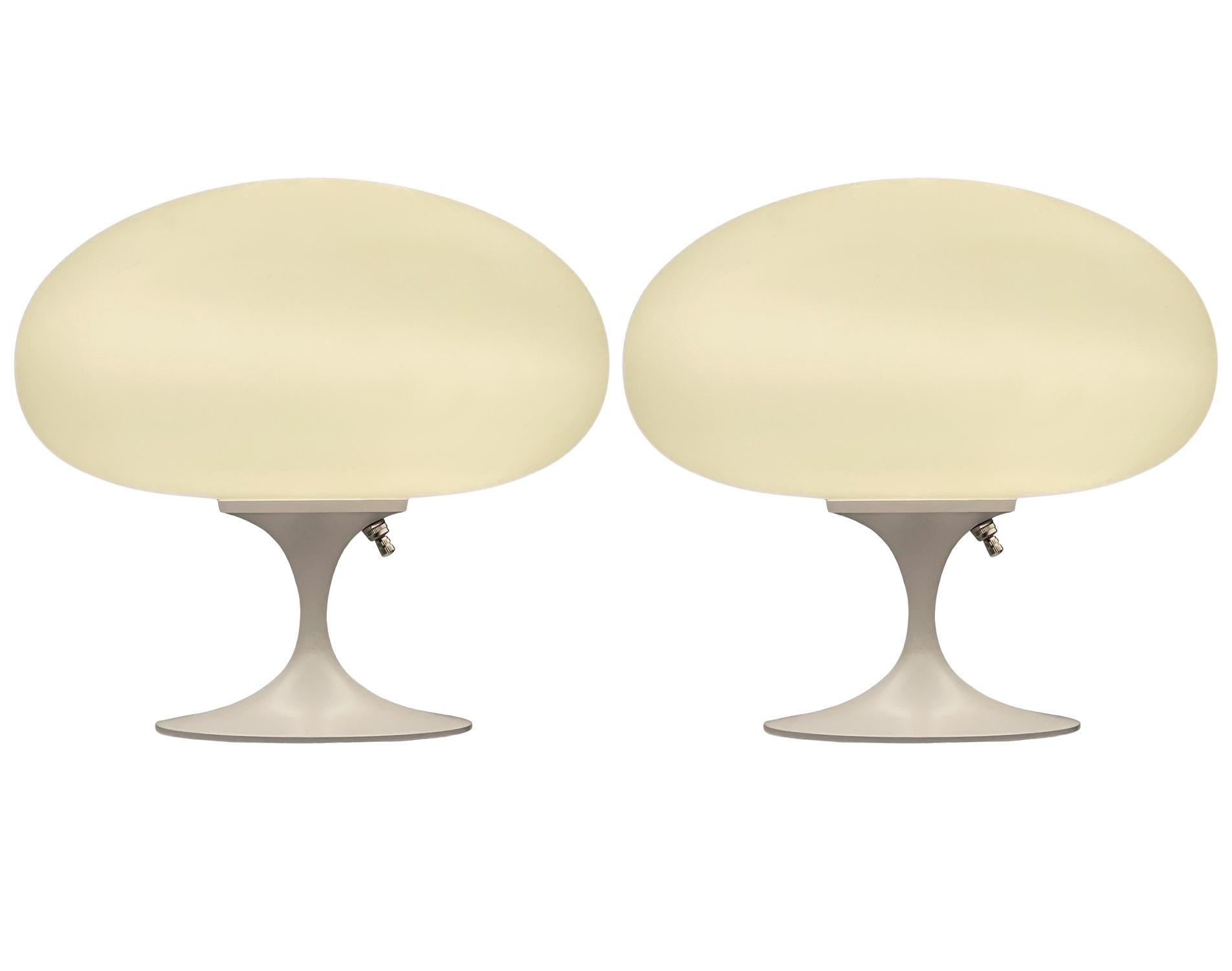 A gorgeous matching pair of tulip form table lamps after Laurel Lamp Company These feature white powder coated cast aluminum bases with mouth blown frosted white glass shades. The price includes the pair as shown.