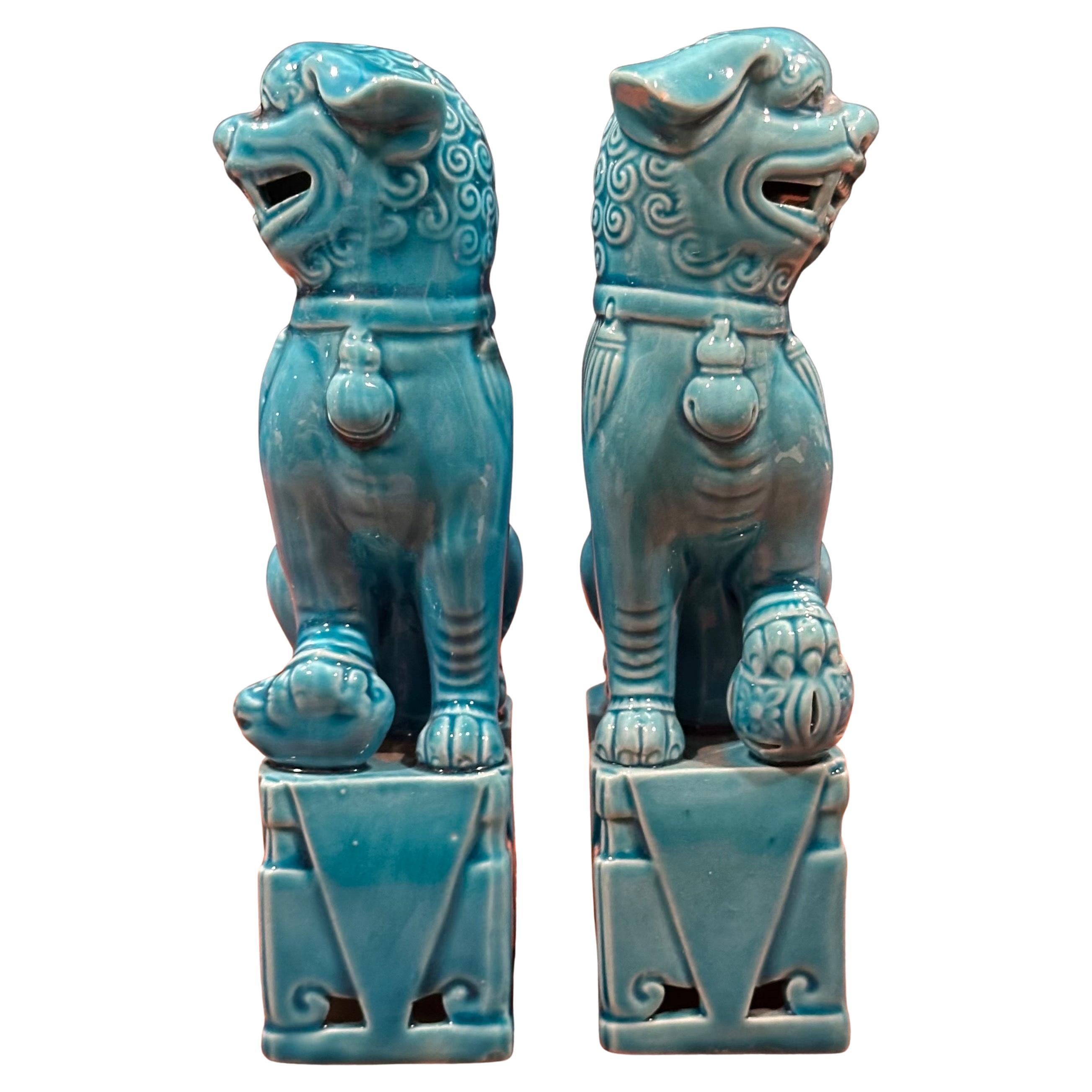Excellente paire de sculptures de chien foo en céramique bleu turquoise du milieu du siècle, vers les années 1960. Ces gardiens symboliques présentent une belle teinte turquoise et sont en très bon état vintage, sans éclats ni fissures. Les chiens