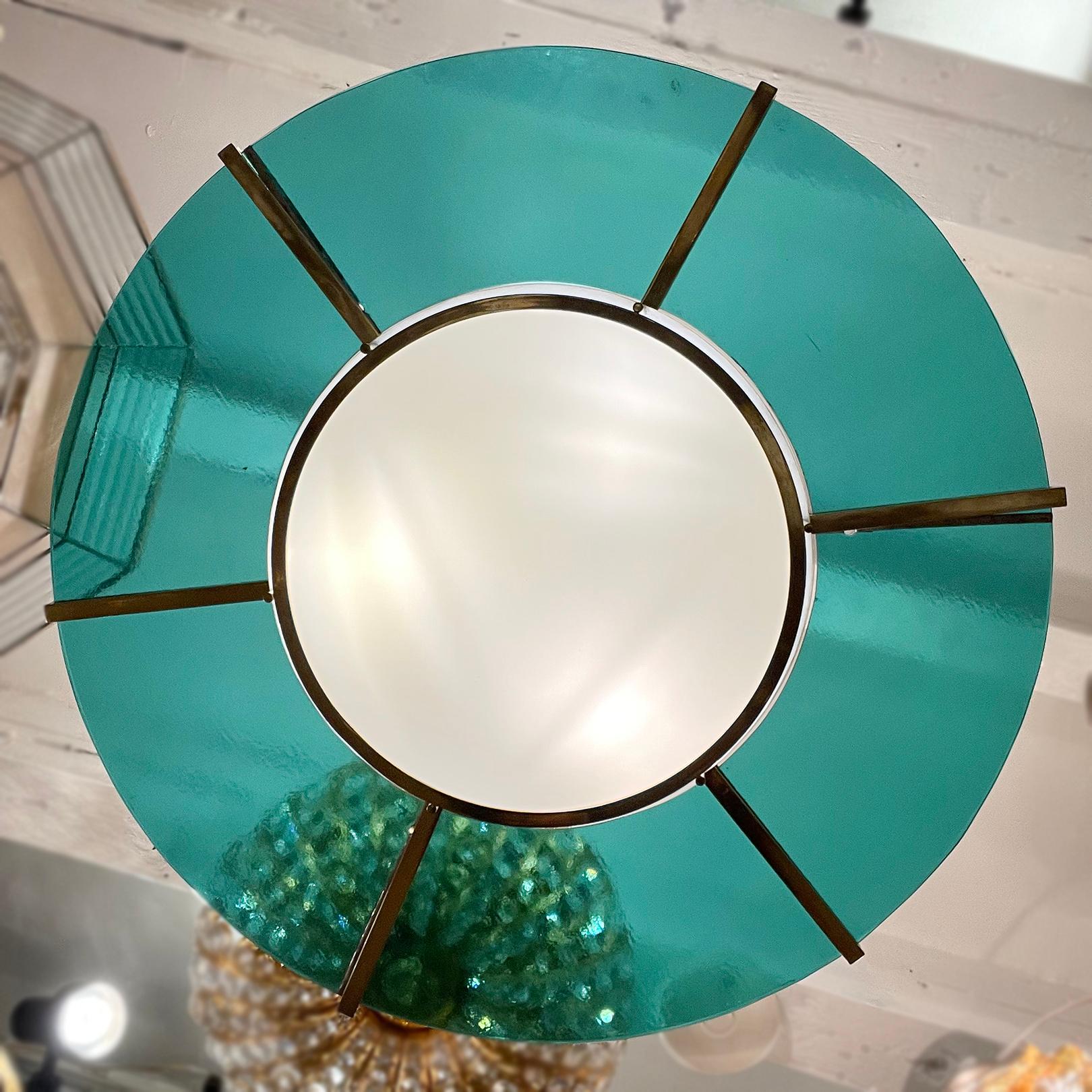 A pair of 1960's Italian light fixtures with 6 interior lights. Polished bronze frame with turquoise glass inset. Sold individually.

Measurements:
Diameter: 32