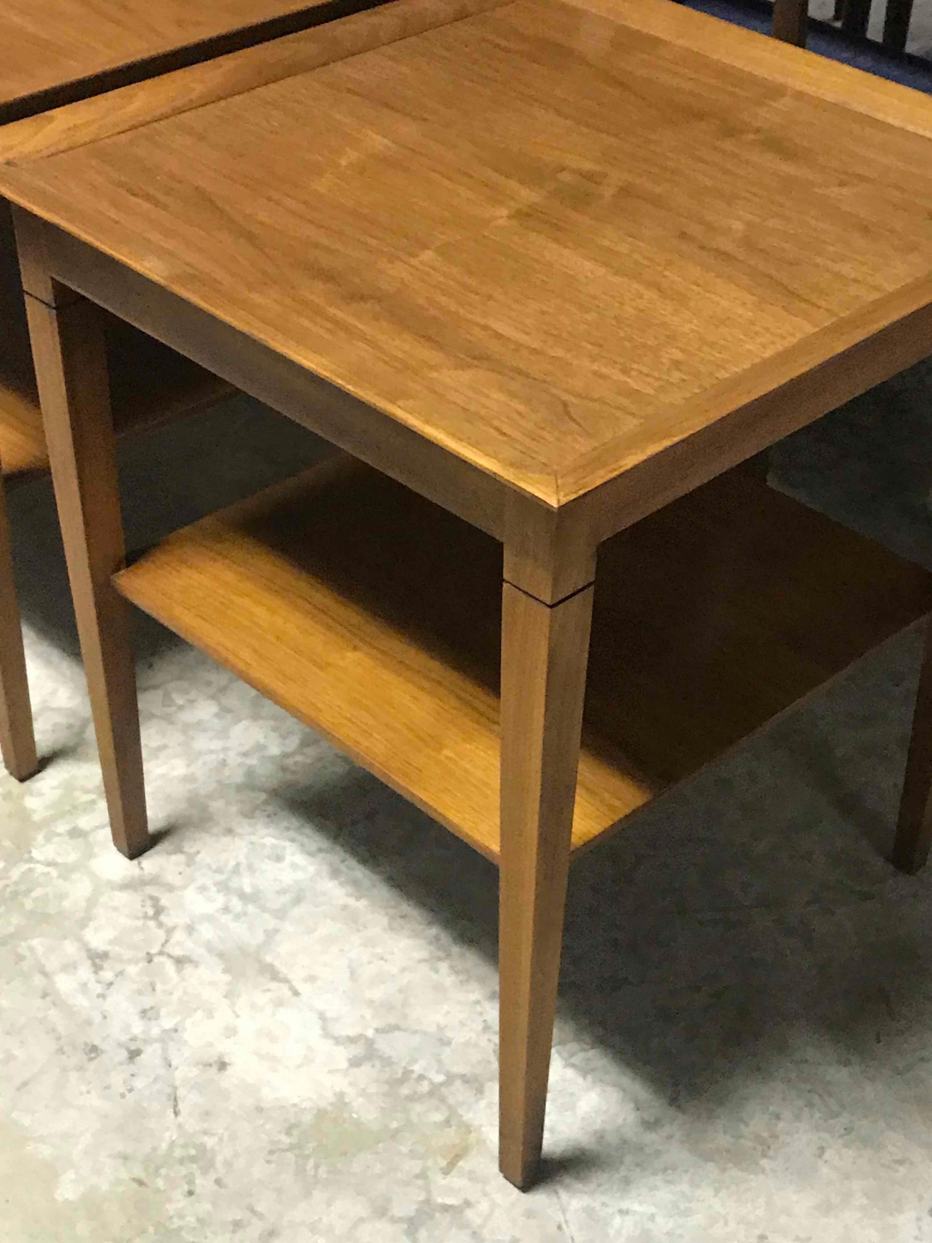 A pair of mid-century two-tier English side tables with slightly tapered legs. 