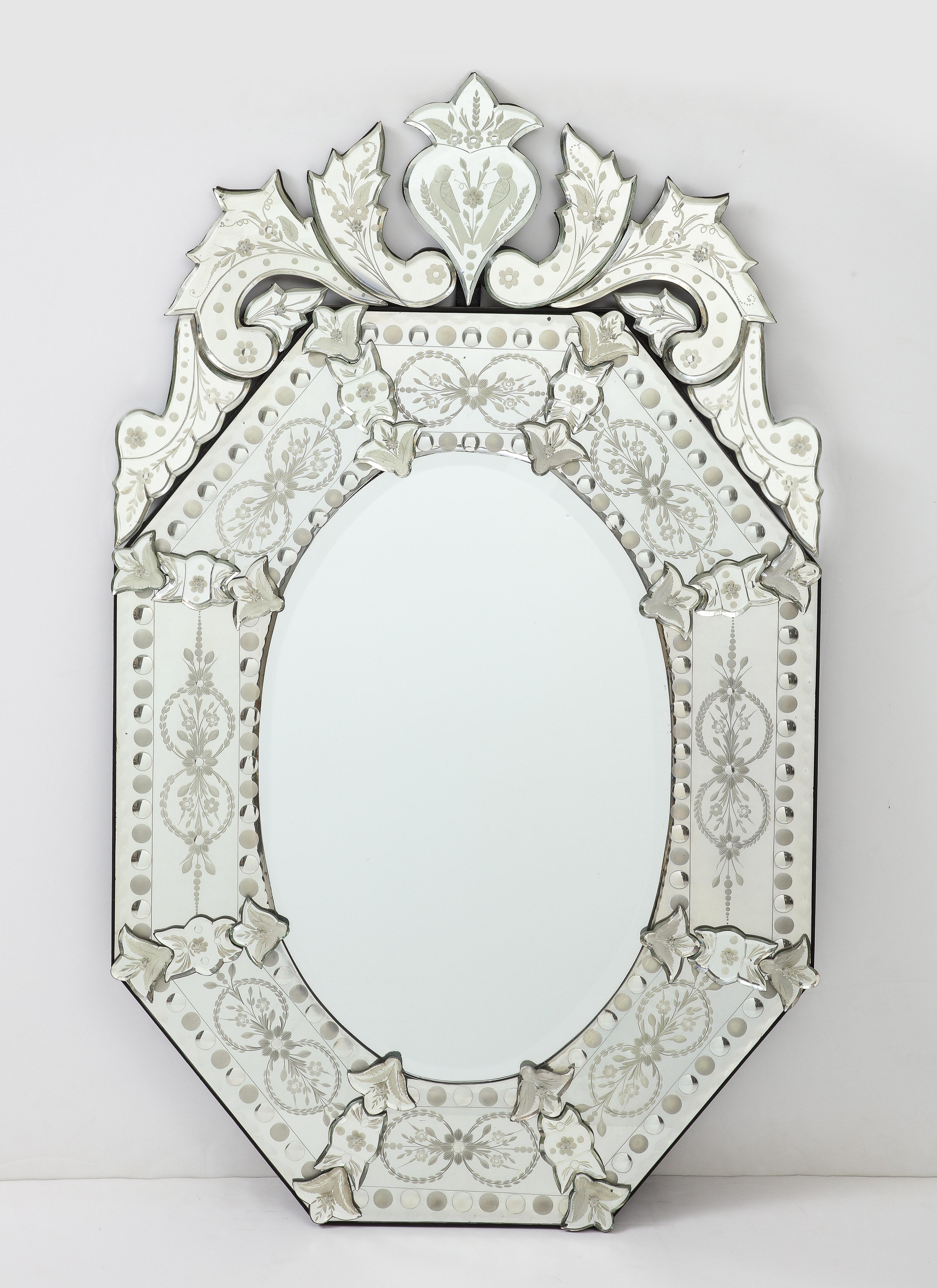 Paire de miroirs vénitiens italiens du milieu du siècle, avec des détails floraux gravés, montés sur des panneaux de bois noir.