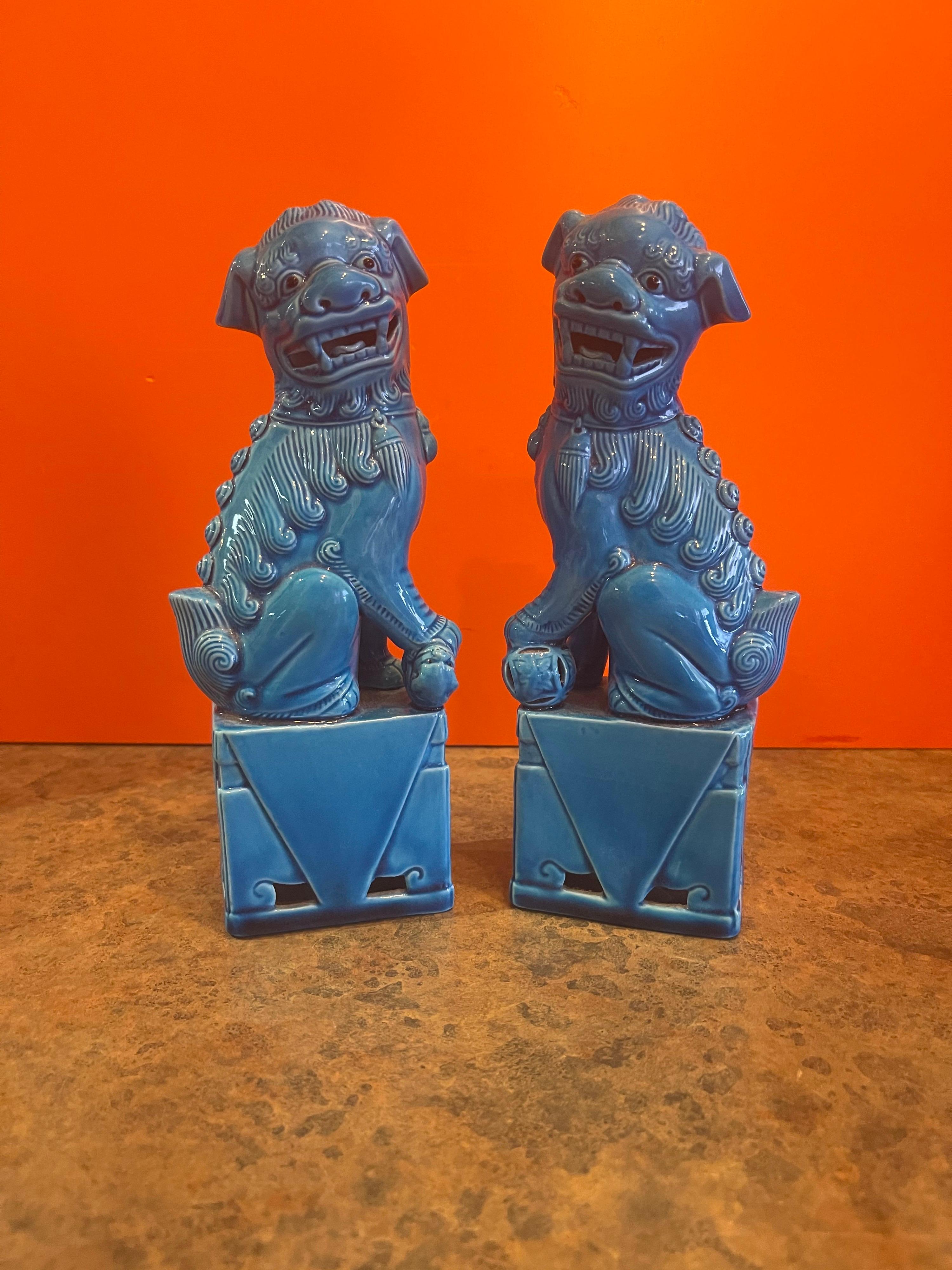 Pair of mid-century vintage turquoise blue foo dog sculptures, circa 1970s. These symbolic guardians have a beautiful blue turquoise ceramic hue and measure 7