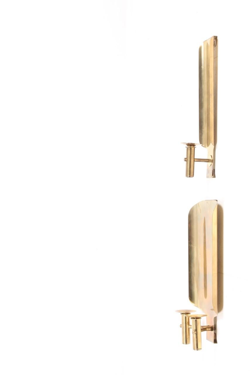 Pair of wall candelabras in solid brass, each pair holds two candles. Made in Denmark by Torben Orskov in the 1950s.