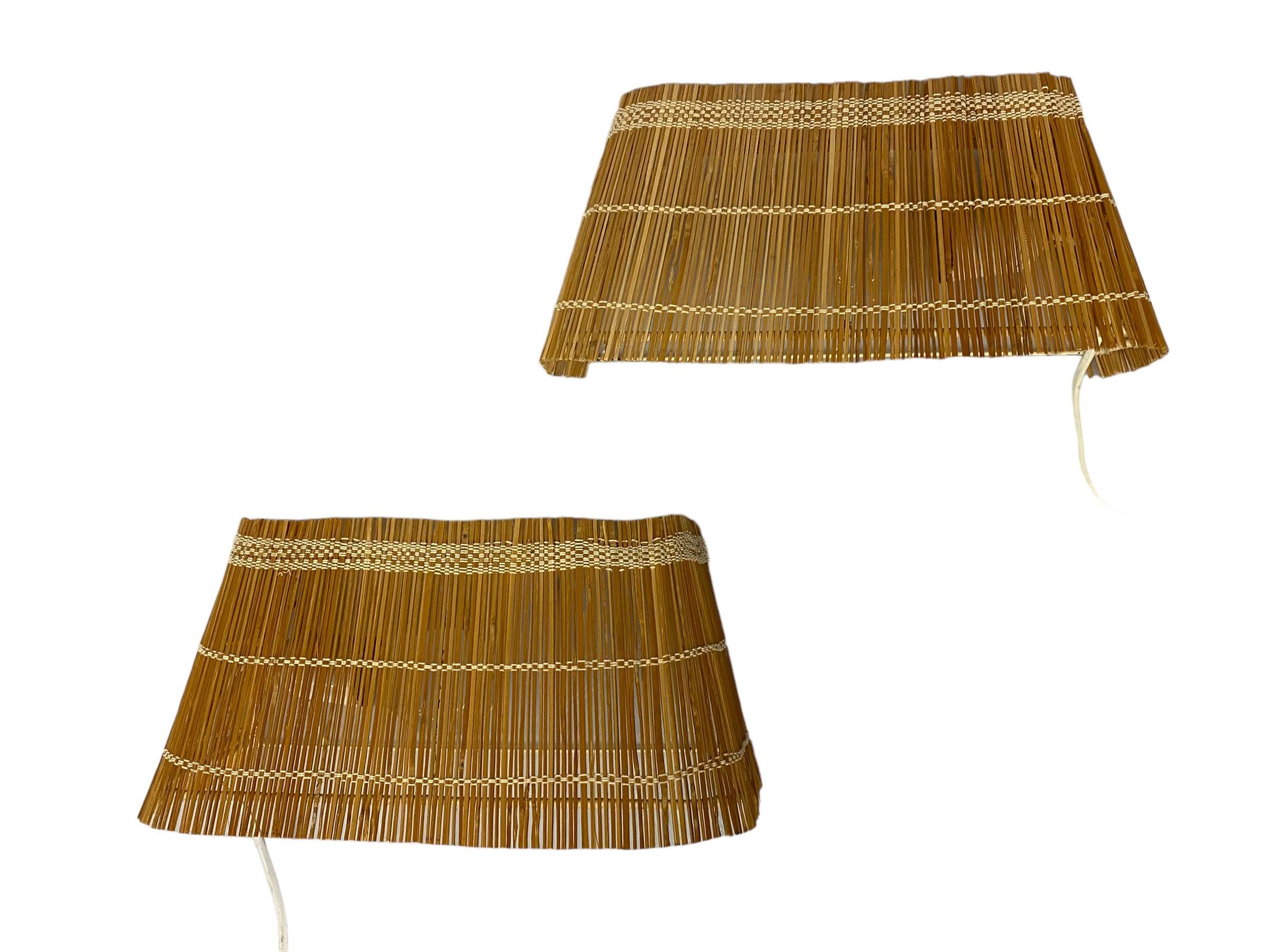 This type wall lamps was made by almost all lamp factories in the 1930-1960s including Taito, Idman, Itsu and Orno. When the light filters through the rattan shades the lamps have a very warm look that's very appealing to people. 
Unfortunately this
